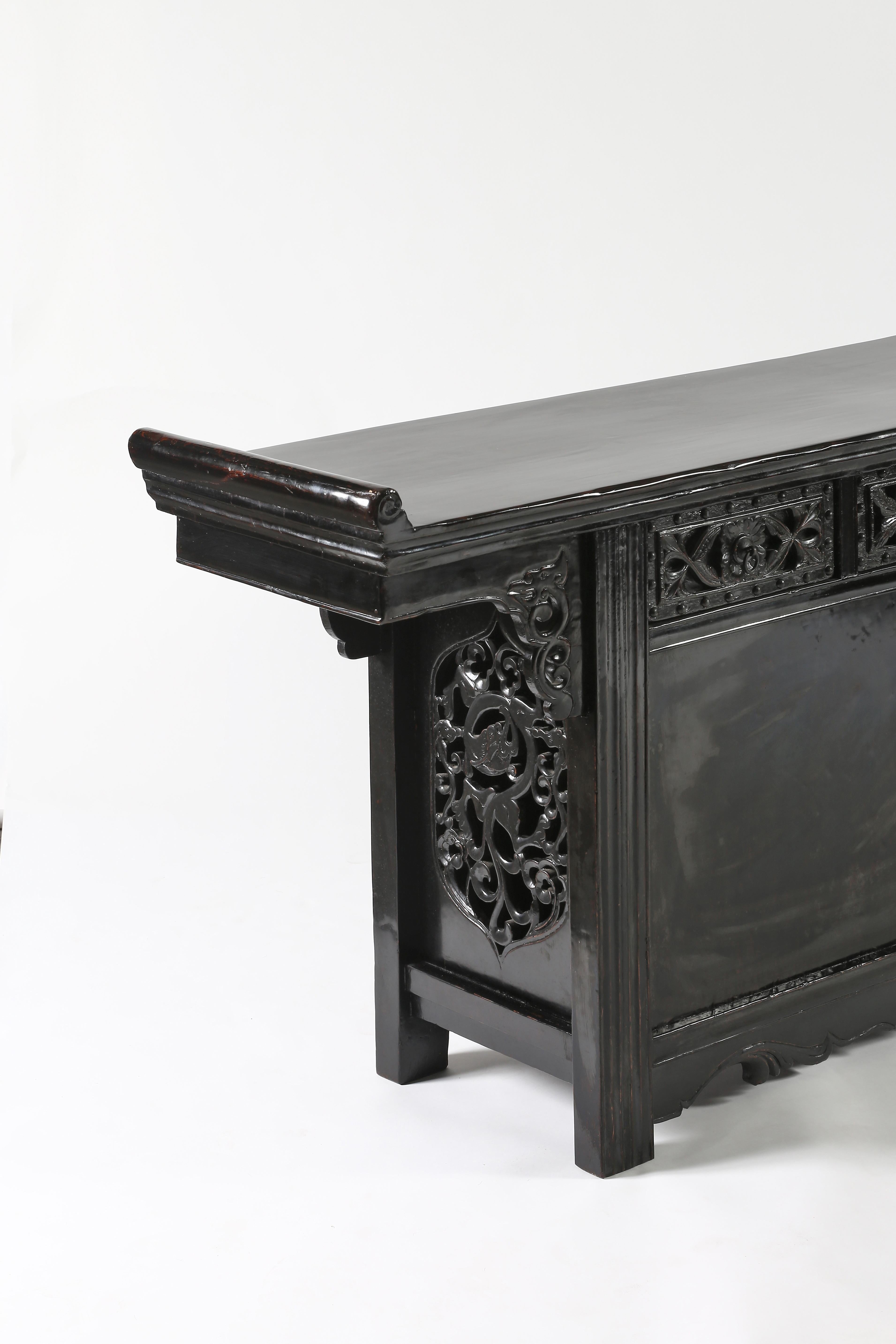 The superb altar coffer with a floating panel top, inserted within the rectangular frame ending with everyted flanges, five drawers decorated with relief carved floral and foliage carving and iron studds, above two doors opening to an open storage