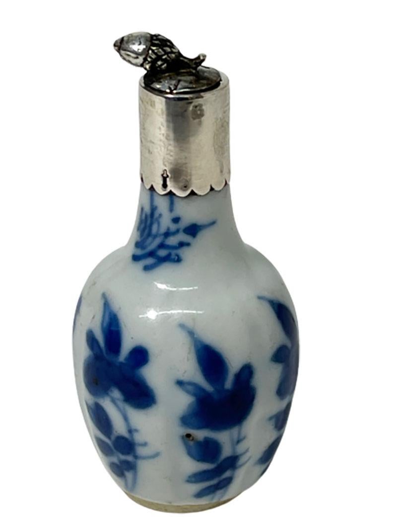 18th century Chinese porcelain miniature blue and white Kangxi bottle vase

A porcelain Chinese blue and white porcelain Silver mounted and stopper bottle vase Kangxi, (1662-1722)

With a scene of floral decor and has a Silver acorn as