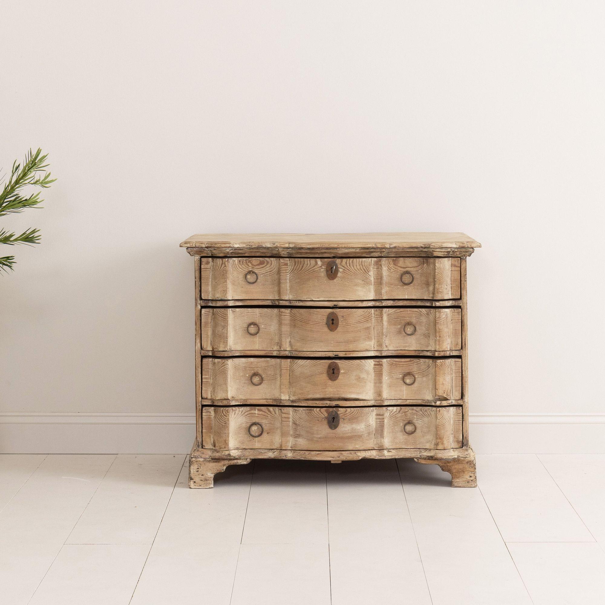 A Danish commode from the 18th c. in original natural patina. A shaped top and beautifully carved arbalette shaped drawers with original iron hardware standing on a shaped bracket base. 

We offer expedited, fully-insured, custom packaged /