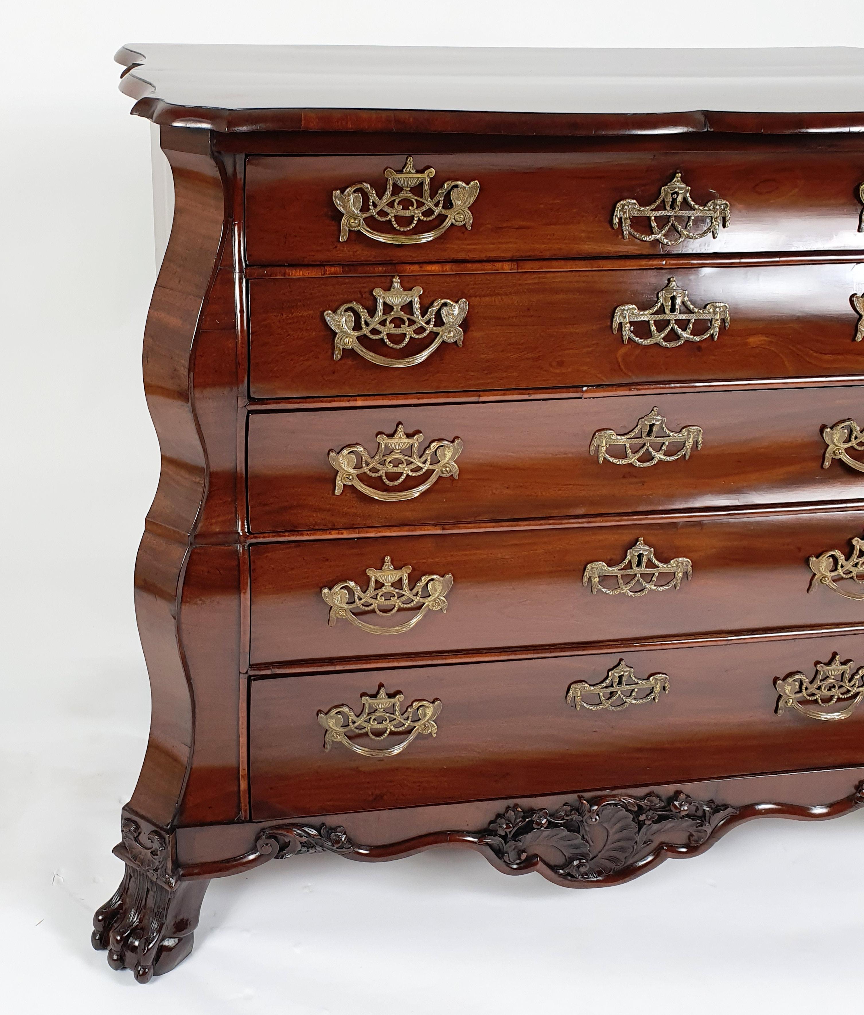This superb and gorgeous late 18th century Dutch figured mahogany bombe shaped chest features 5 long drawers on carved ball and claw front feet with a lovely rococo carved apron. The chest measures 38 in – 96.5 cm wide, 22 ¼ in – 56.5 cm deep and 34