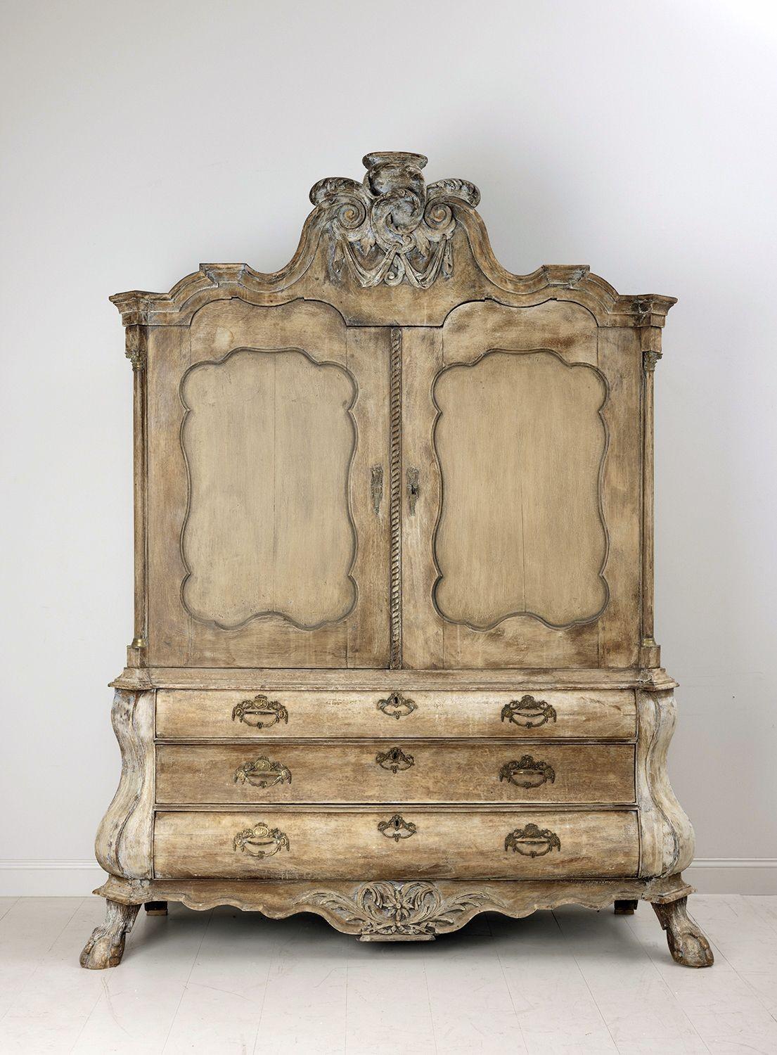A rare and impressive hand-carved cabinet with original brass hardware, Corinthian capitals, and column base escutcheon caps. This 18th c. Dutch oak linen press from the Rococo period has been hand-scraped to the original paint with later paint on
