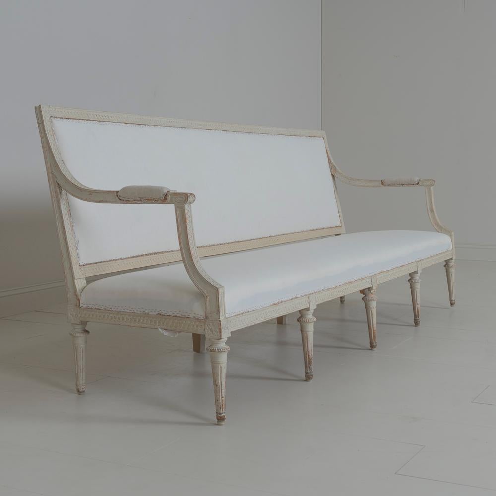 A Gustavian period sofa bench from the 18th century. Hand scraped to the original paint. Made by chair maker Jacob Malmsten, Stockhom 1780-1788. This piece is exceptionally well made and has retained its original webbing. The back, arms, and seat