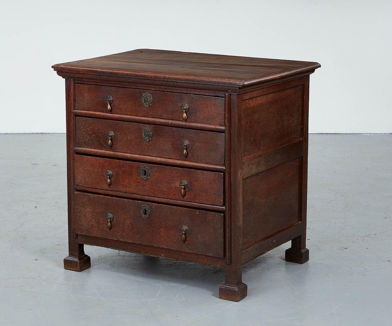 An 18th century oak dresser with pronounced cornice around top over three drawers plus one deeper drawer all with drop pulls and escutcheons, on tall stile legs with molded block feet.  A rare and distinctive form associated with the East Anglian