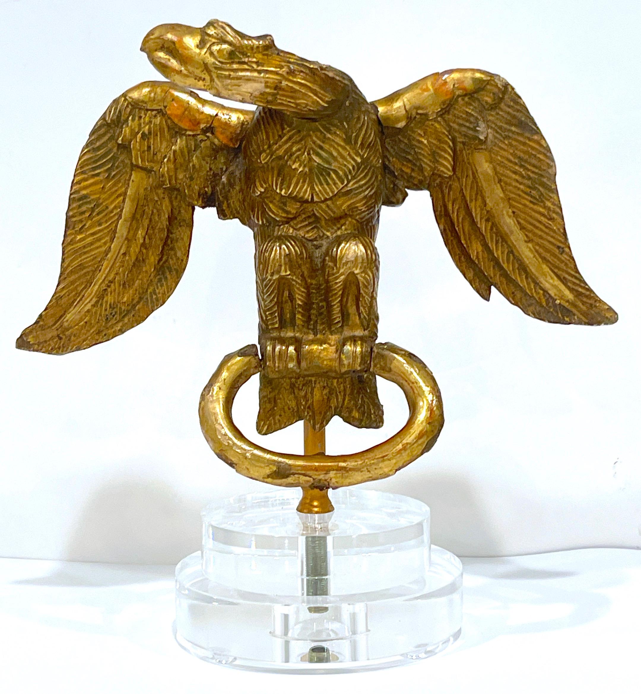 This 18th-century English carved giltwood eagle, hailing from the Georgian period, is a magnificent example of artisan cabinetry from the era. The eagle carving is expertly carved from giltwood and gessoed, showcasing the skill and artistry of the