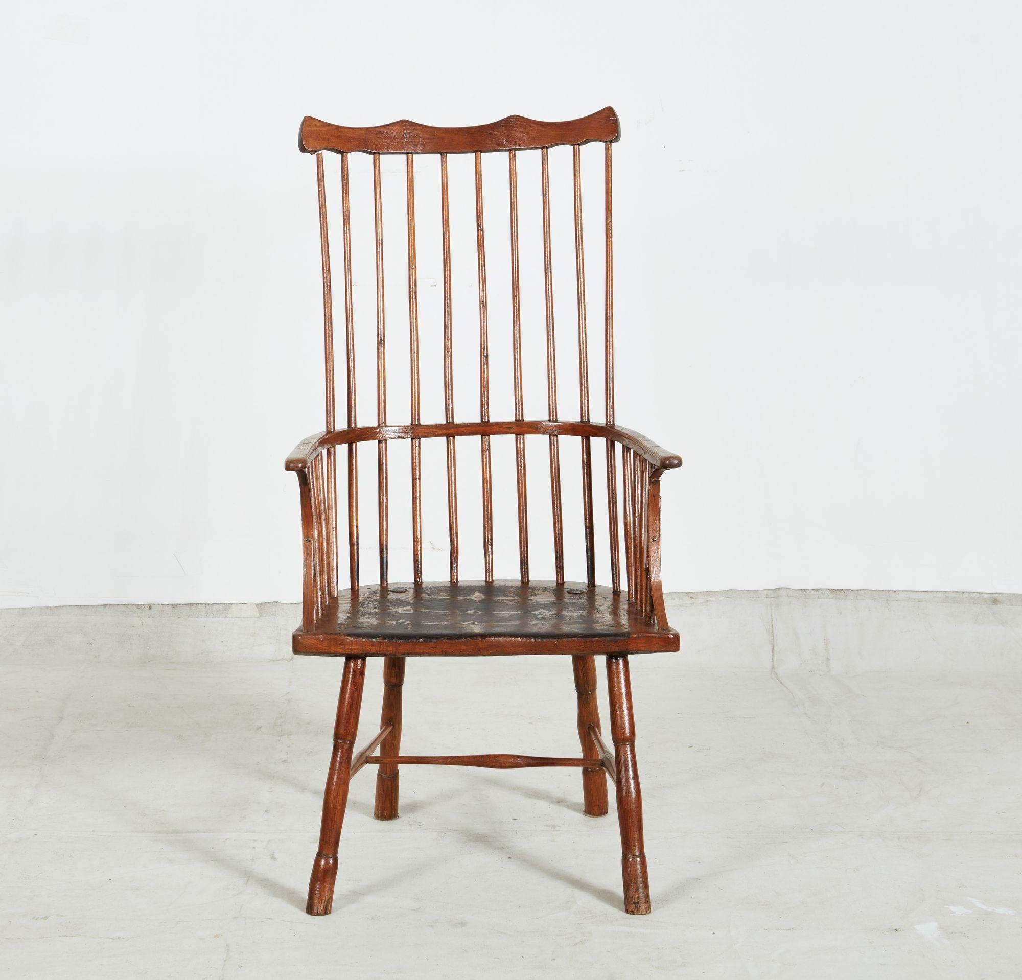Fauteuil Windsor rustique à dossier en peigne, avec une crête en forme sur un dossier en fuseau, l'accoudoir étroit avec des supports en bois courbé et des fuseaux tournés, l'assise peu profonde sur des pieds tournés reliés par des brancards en 