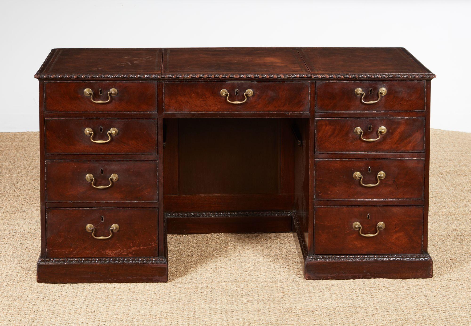 Bureau à piédestal en acajou anglais du XVIIIe siècle, avec un plateau en trois parties avec insertion de cuir doré, un tiroir central et deux rangées de quatre tiroirs de chaque côté. Ce bureau est orné de détails raffinés tels que des moulures à