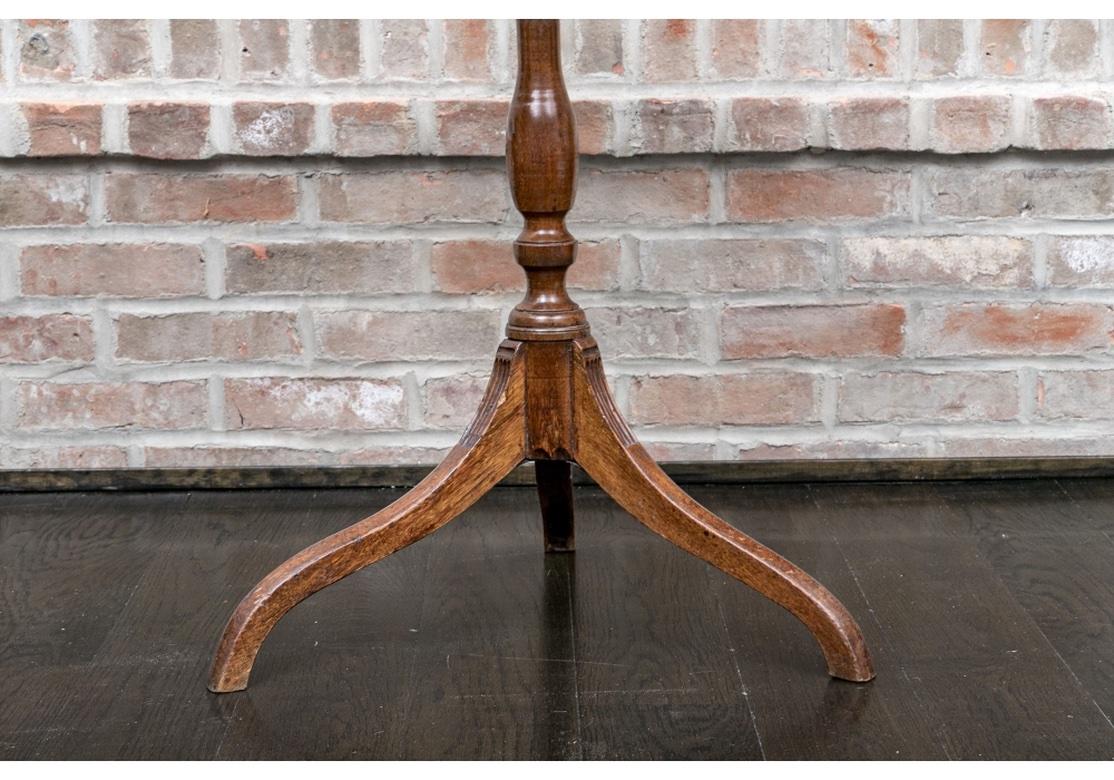 An authentic Period George II mixed wood Wine Stand with fine traditional form. The Stand has a fine grained mahogany top and is supported by a turned oak vasiform column terminating in sinuous legs having carved fluted insets. 

The Wine Stand