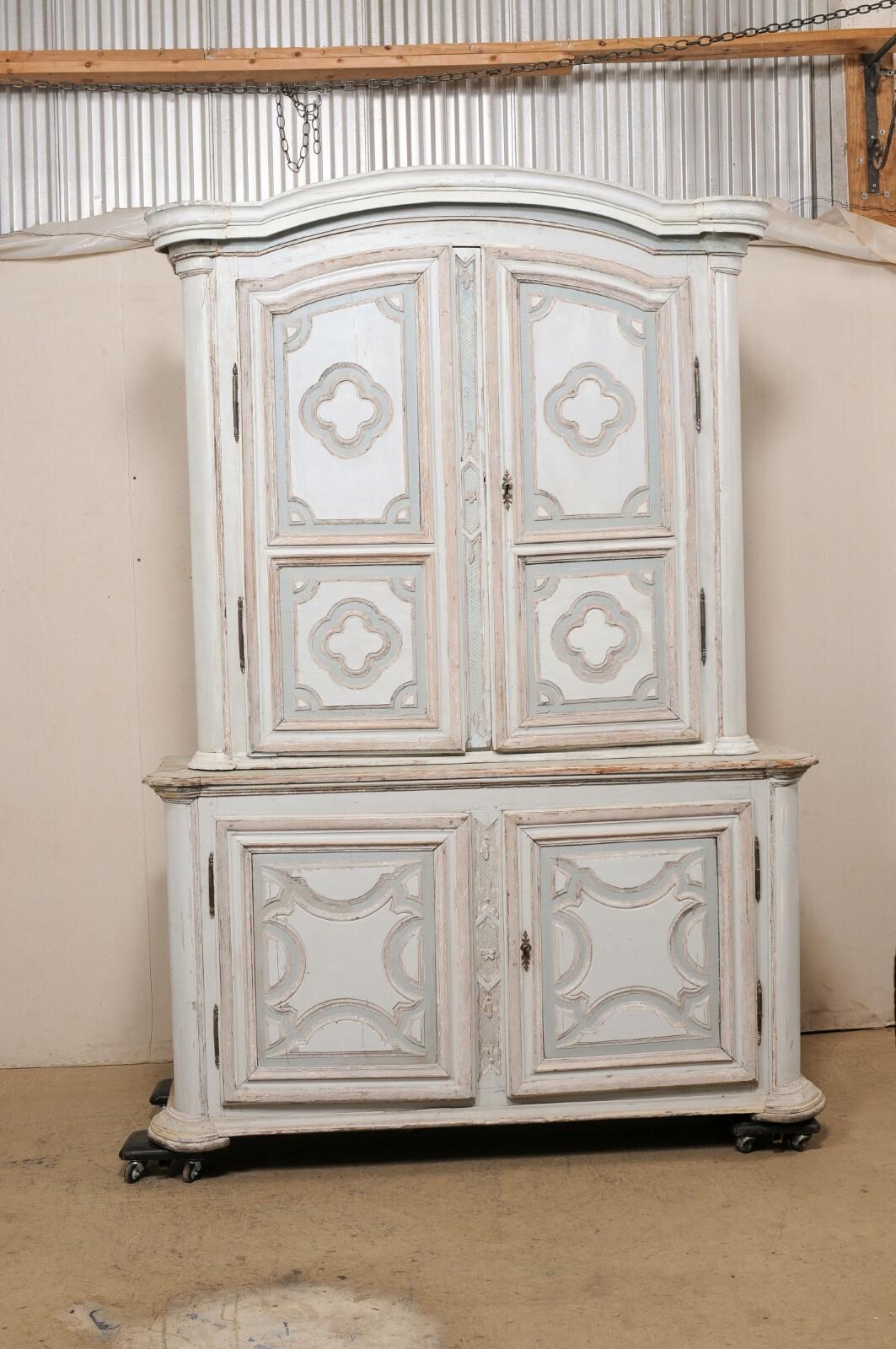 A large French carved and painted wood storage cabinet from the 18th century. This antique buffet à deux-corps from France features a thickly molded center top cornice with subtle arch center, atop the upper cabinet which houses a pair of upper