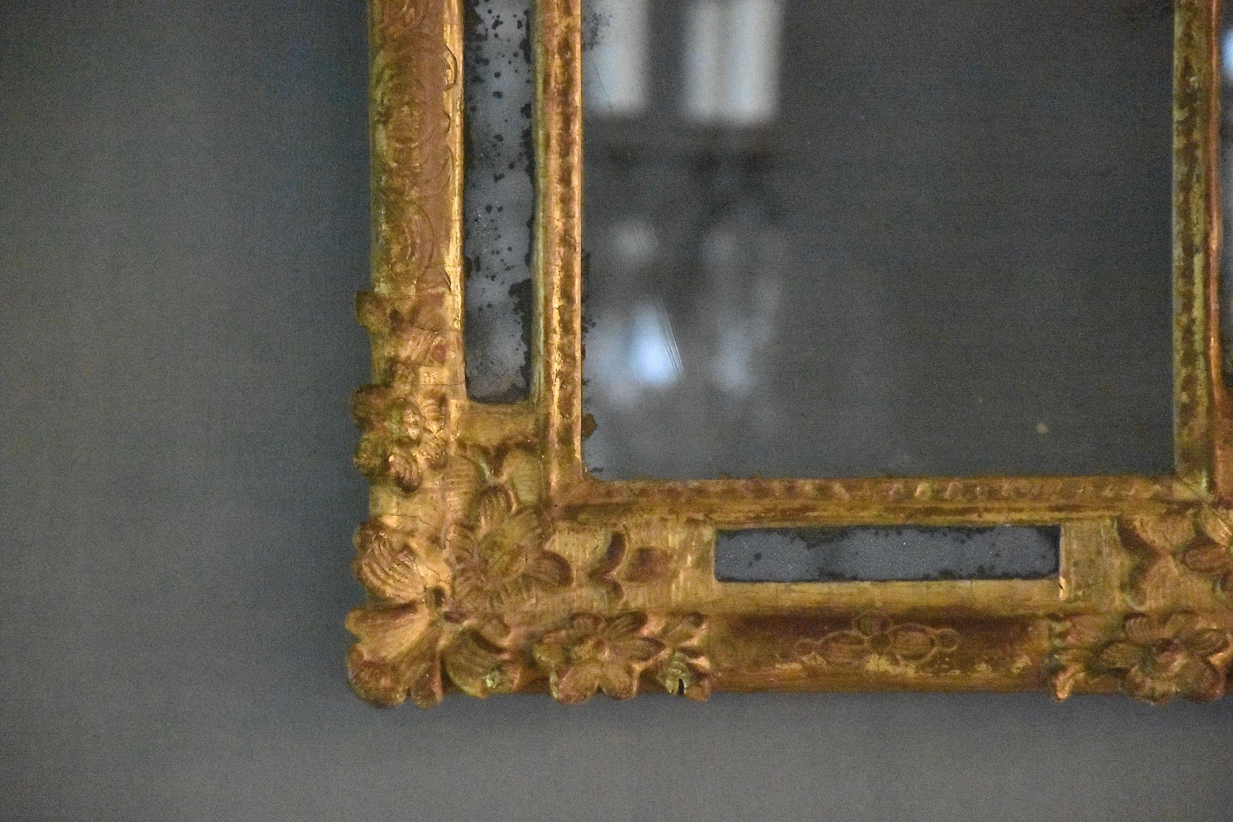 A magnificent carved and gilded French mirror, period Louis XIV.
The crest and the frame decorated with flowers and acanthus leaf. 
Original mercury glass. 
Very beautiful piece and in very good antique condition!
