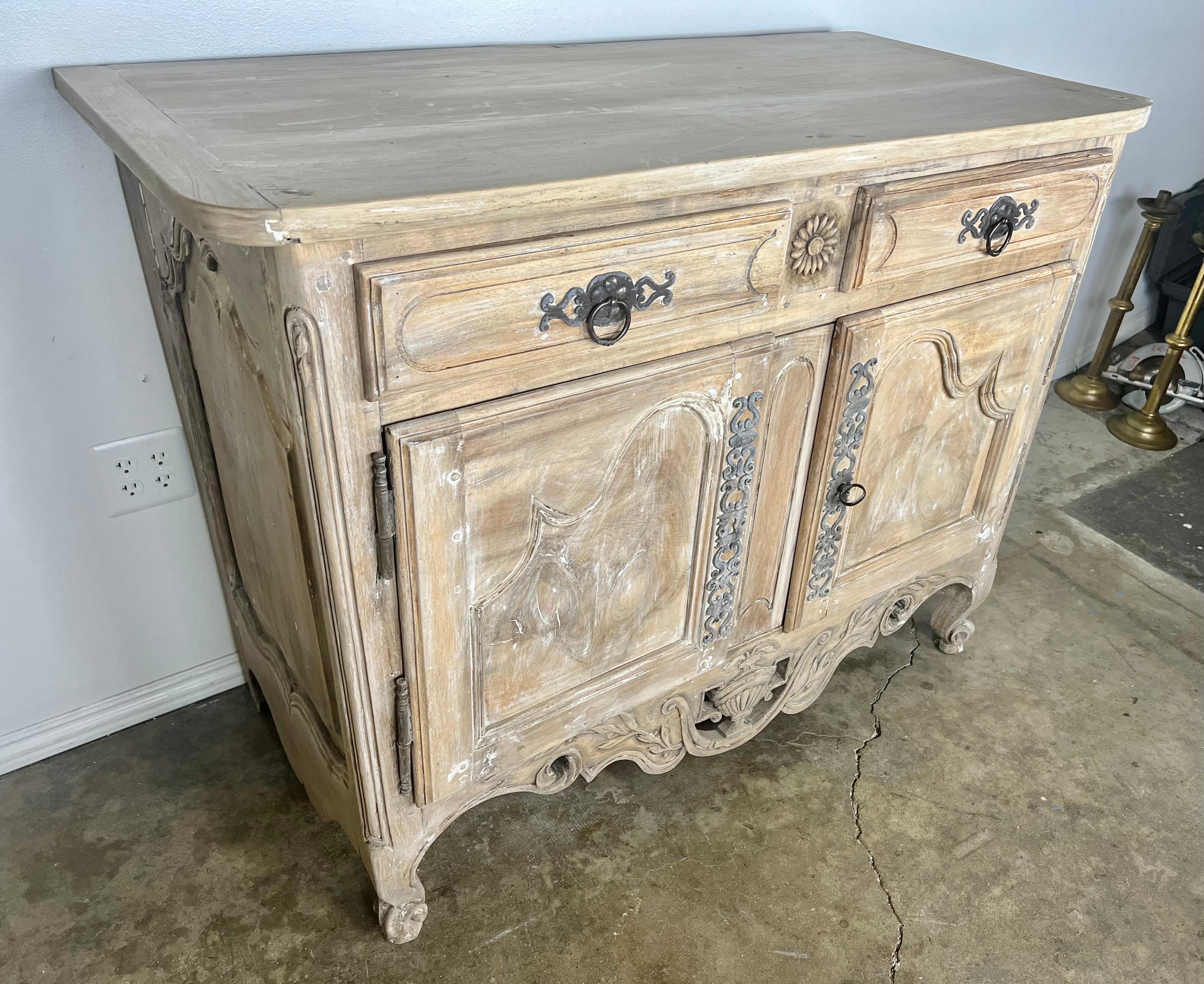 18th C. Carved French Provincial buffet with original metal hardware.  The buffet stands on four cabriole legs.  There is a carved sunflower between the two drawers.  Amazing dovetailing and hand made nails.