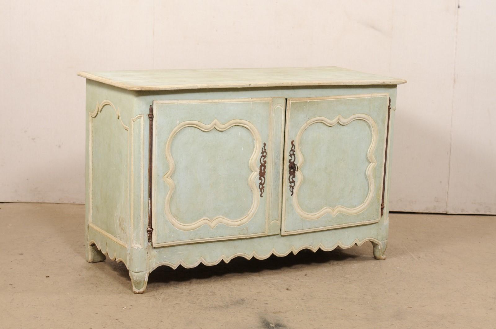 A French painted wood two-door buffet cabinet from the 18th century. This antique cabinet from France has a rectangular-shaped top with rounded front corner edges, which rests above a case of fitted with a pair of decoratively-carved recessed-panel