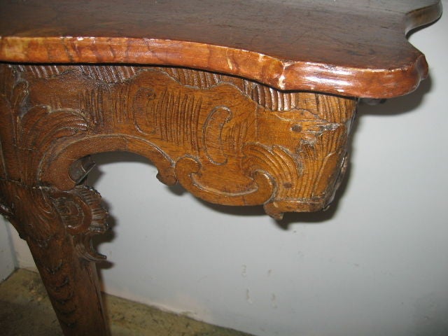 Hand carved oak console with serpentine front. Beautiful faux marble top in colors of rust and gold.