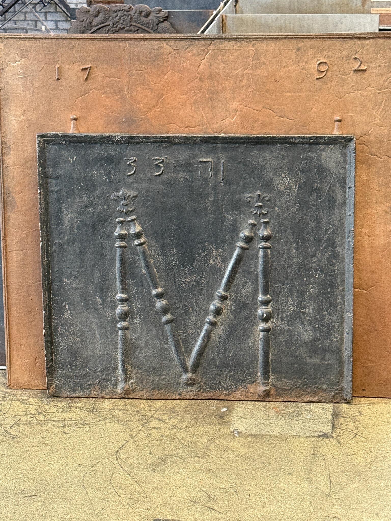 With the year 1733 reversed.

Fleurs de lys (lilies) represented royalty and aristocracy around Europe. The pillar refers to the club of Hercules, his favorite weapon. It symbolizes power. Since antiquity the ‘Pillars of Hercules’ are also the name