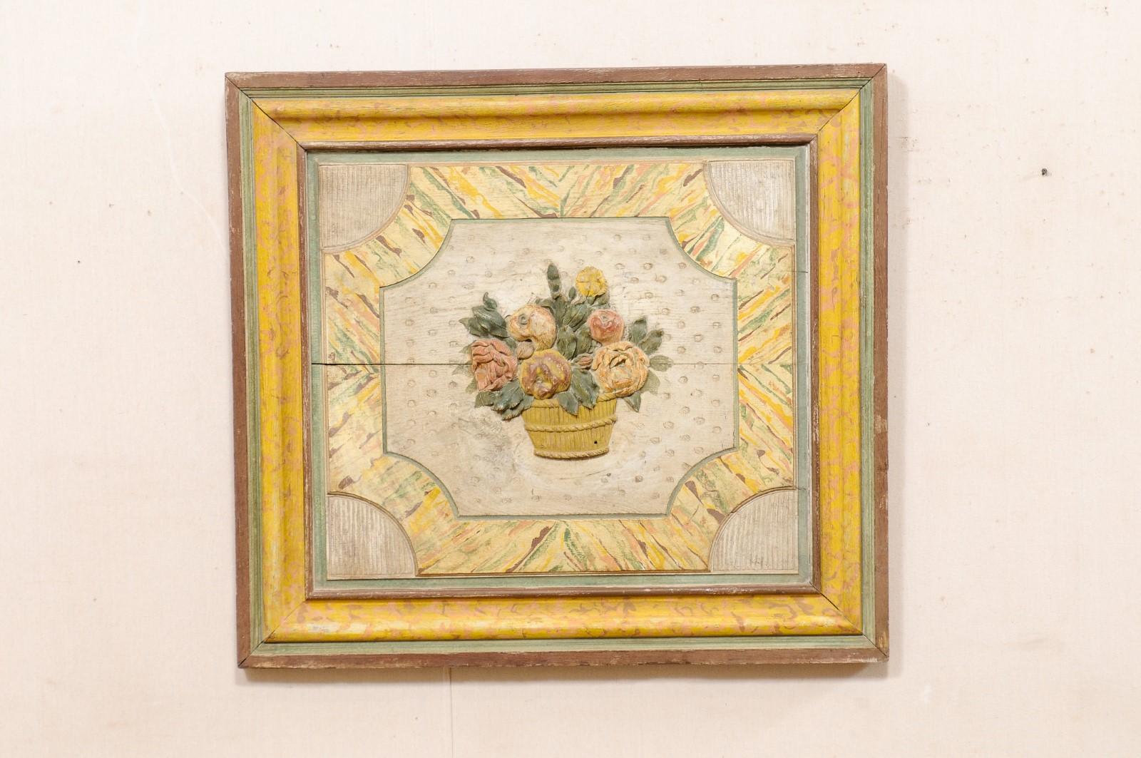 A French floral bouquet carved wooden plaque, with its original paint, from the 18th century. This antique wall decoration from France is nearly-square in shape, featuring a carved bucket with floral bouquet, with a textured and colorful adornment,