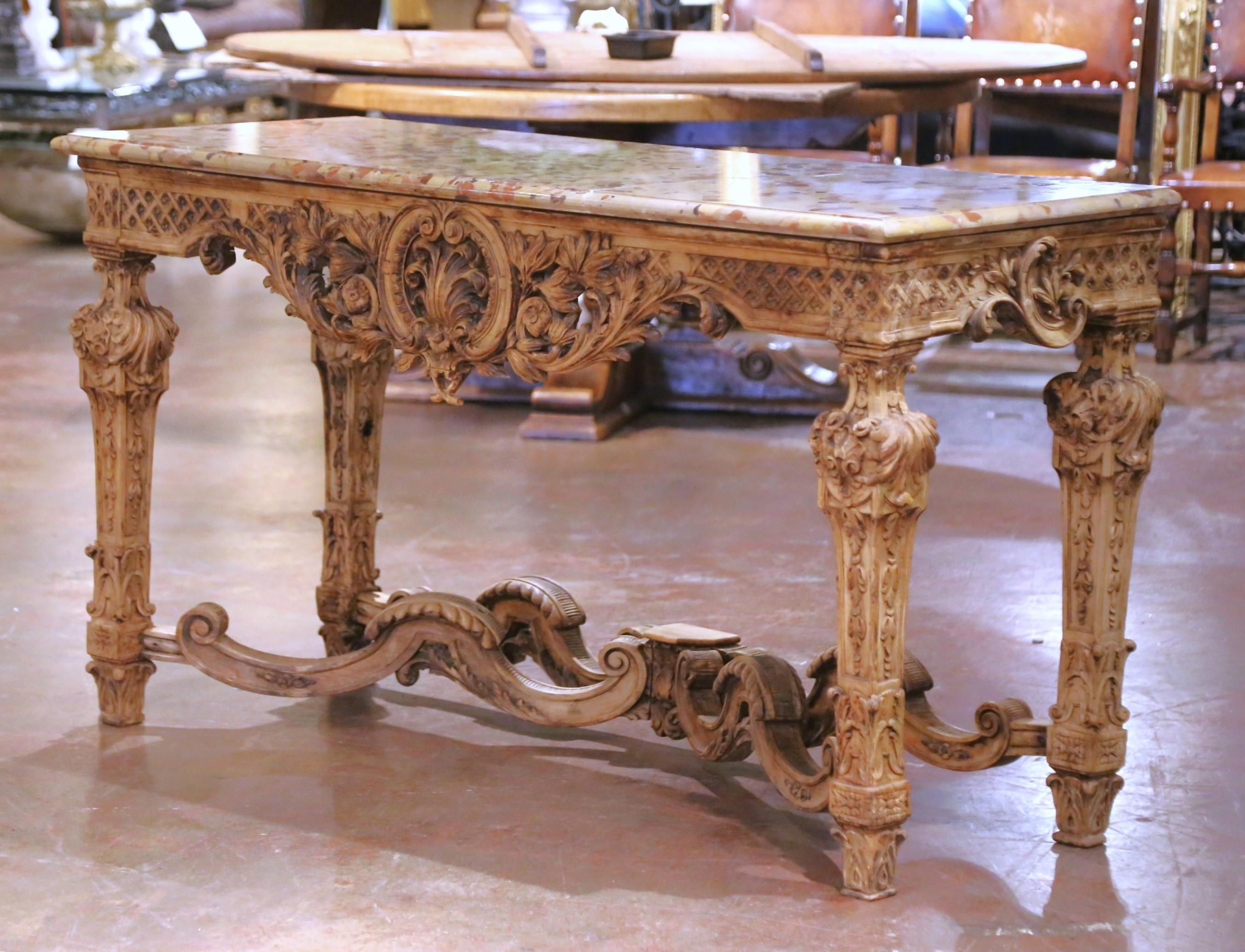 Questo elegante tavolo da salotto antico è stato realizzato in Francia intorno al 1780 nel grandioso stile Luigi XIV. La superficie rettangolare è dotata di un lussuoso piano in marmo Brèche d'Ardèche, ammirato per la sua sorprendente tavolozza