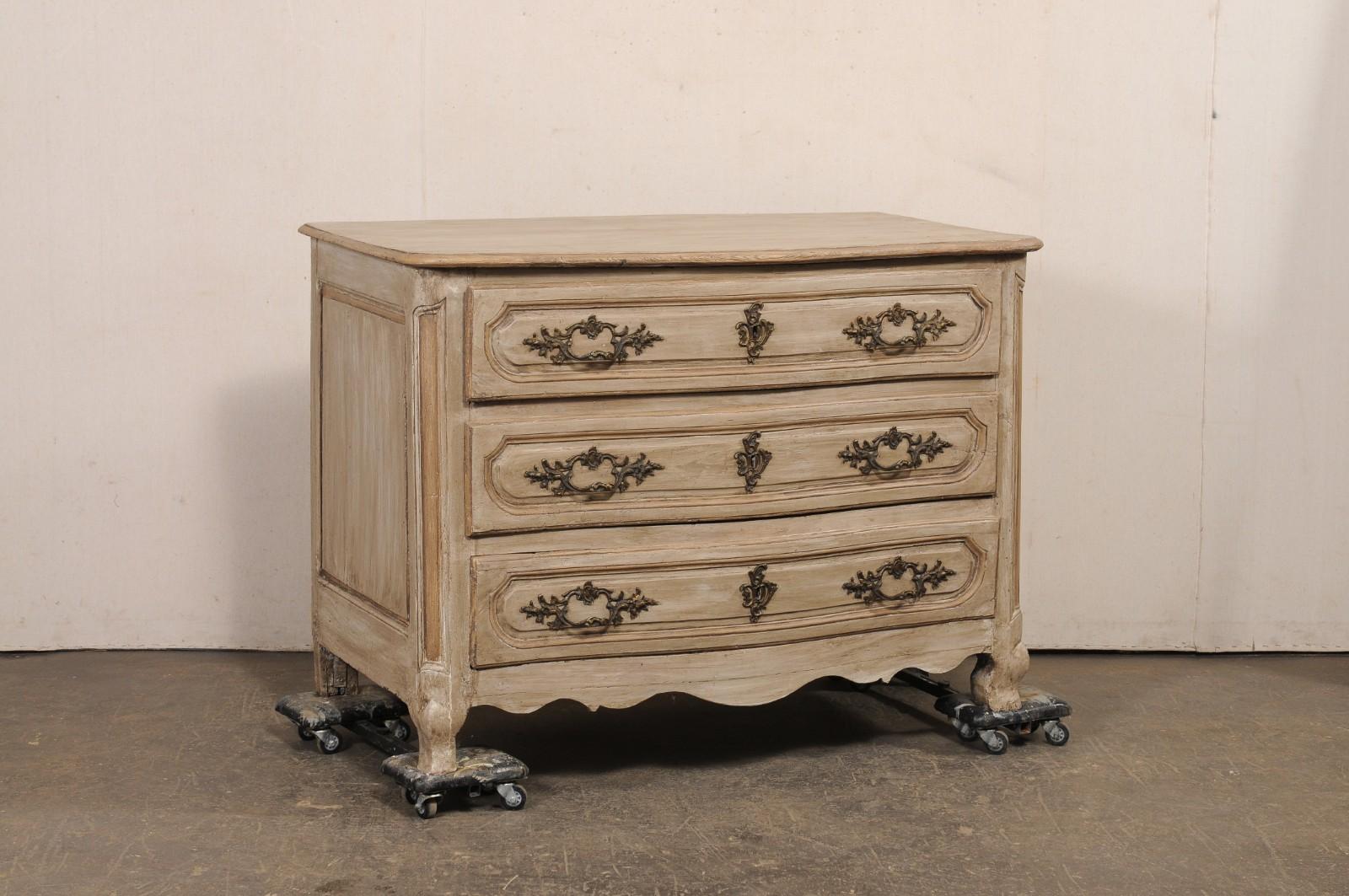 Commodo a serpentina in legno intagliato e dipinto Luigi XV del XVIII secolo. Questa antica commode francese presenta un piano leggermente sporgente, con angoli anteriori dolcemente arrotondati, in cima alla cassa che ospita tre cassetti graduati e