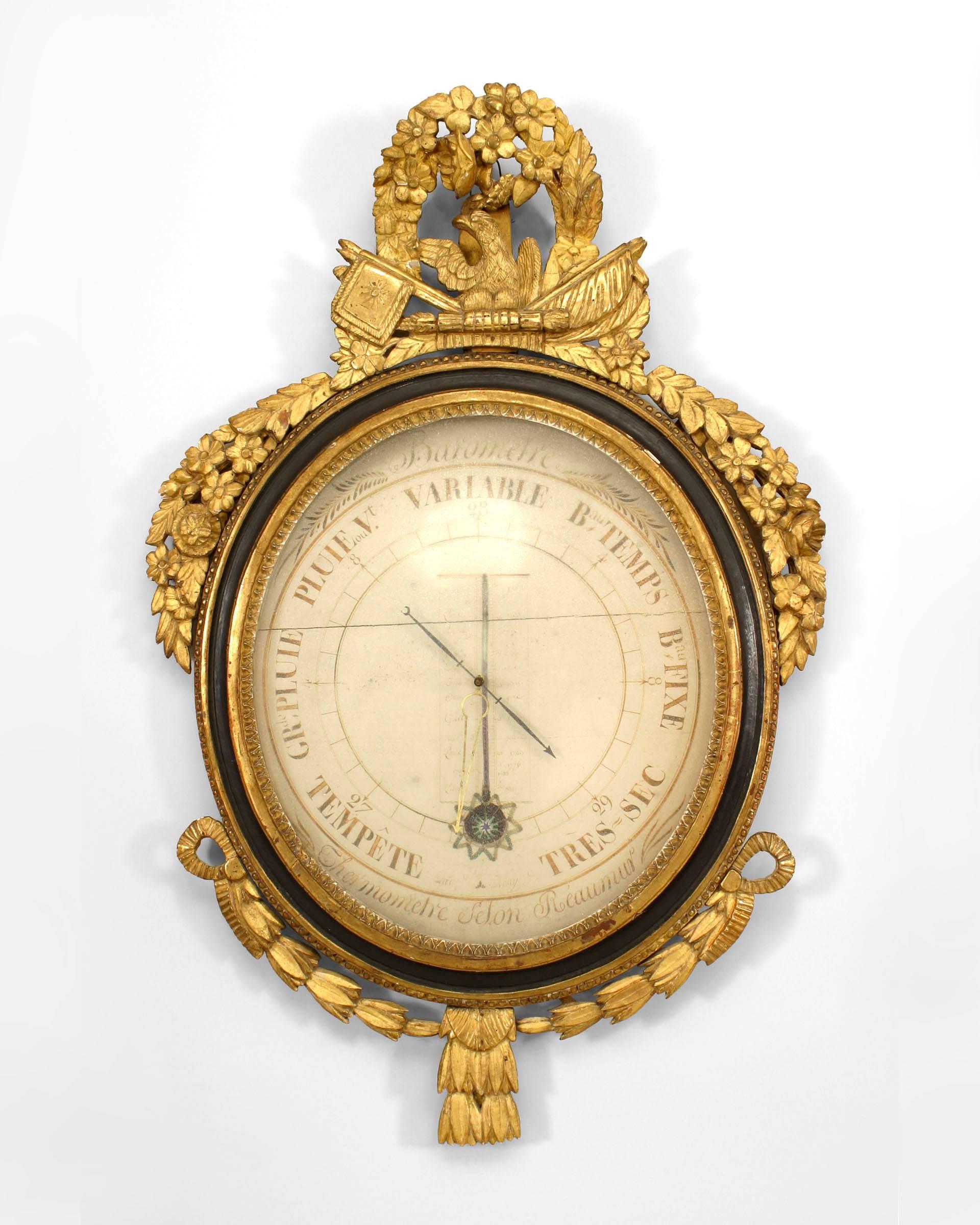 French Louis XVI (18th Century) barometer with original scientific illustrations and mercury vial framed with gilt foliate carvings & ebonized trim and a perched eagle pediment.
