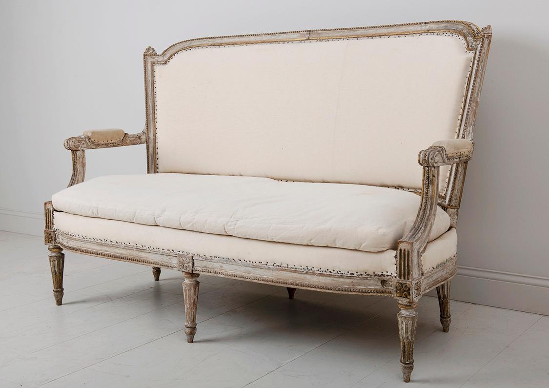 A lovely example of a French Louis XVI period banquette or canapé wearing original paint with traces of gilt. Circa 1780.