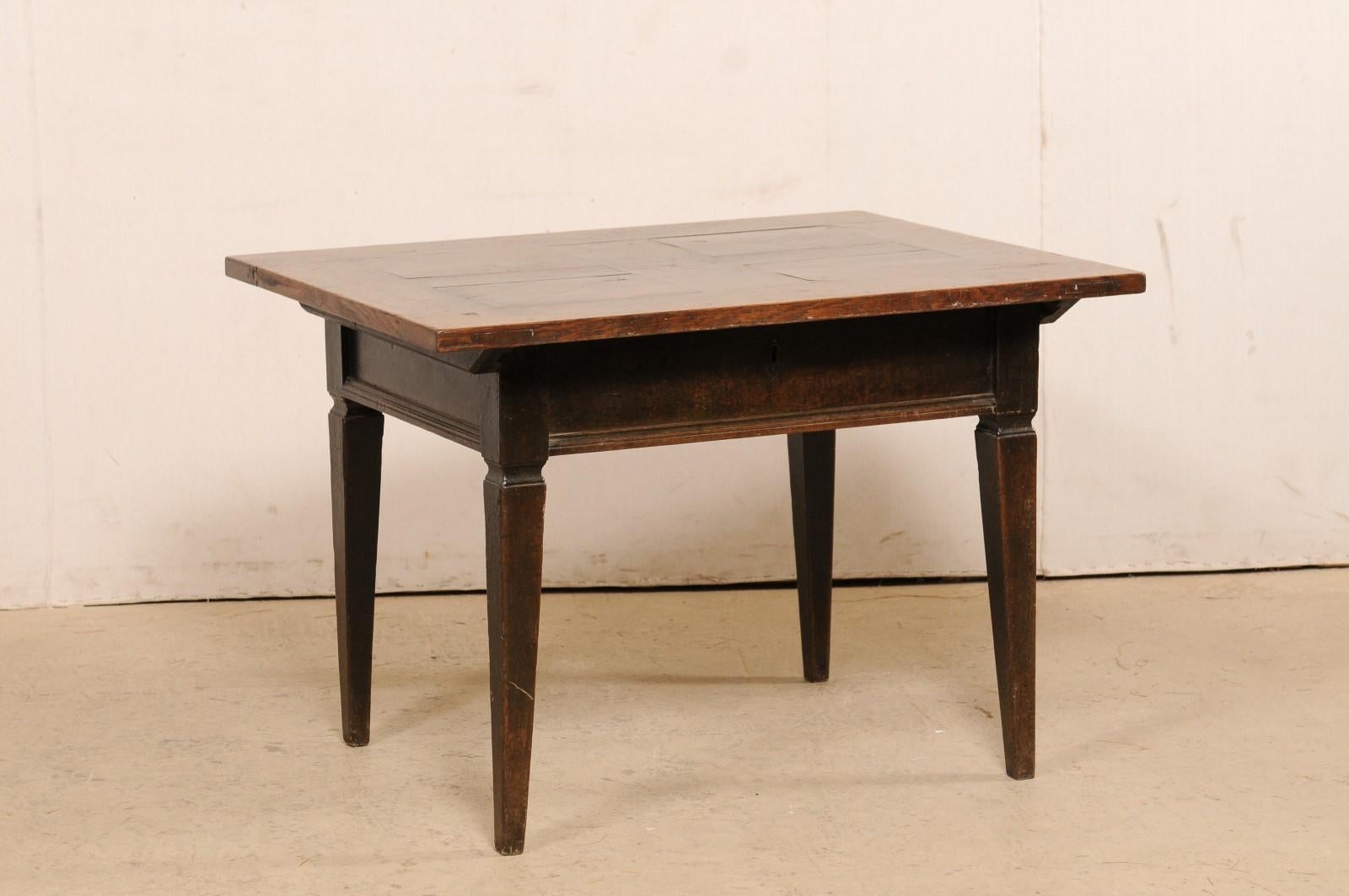 A French occasional table with star accent from the 18th century. The antique oak table from France features a rectangular shaped top, with a decorative star medallion inlay at it's center, which overhangs the apron below, with straight molding