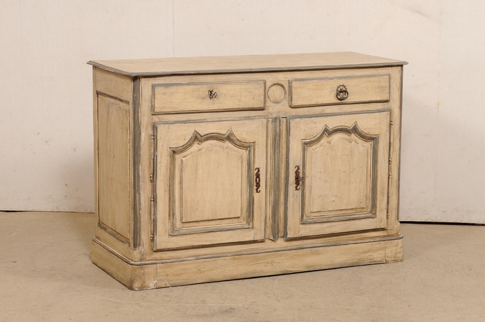 A French painted-wood, two-door buffet cabinet from the 18th century. This antique cabinet from France has a rectangular-shaped top, over a case that houses a pair of half-sized drawers at top (with a circular medallion carved at middle front,