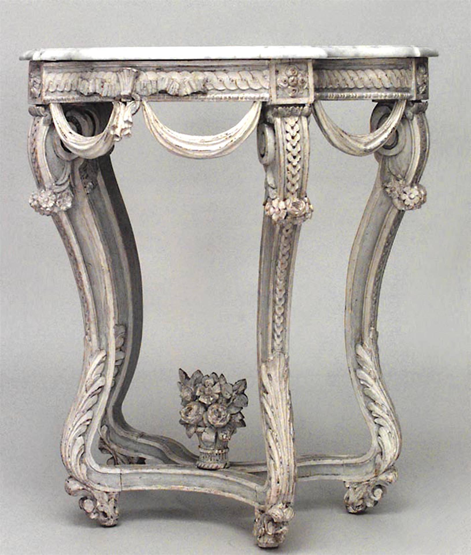 Table console de forme serpentine de style Régence (18/19e siècle) peinte en bleu clair et blanc, avec un plateau en marbre blanc et un motif de feston et une traverse.
