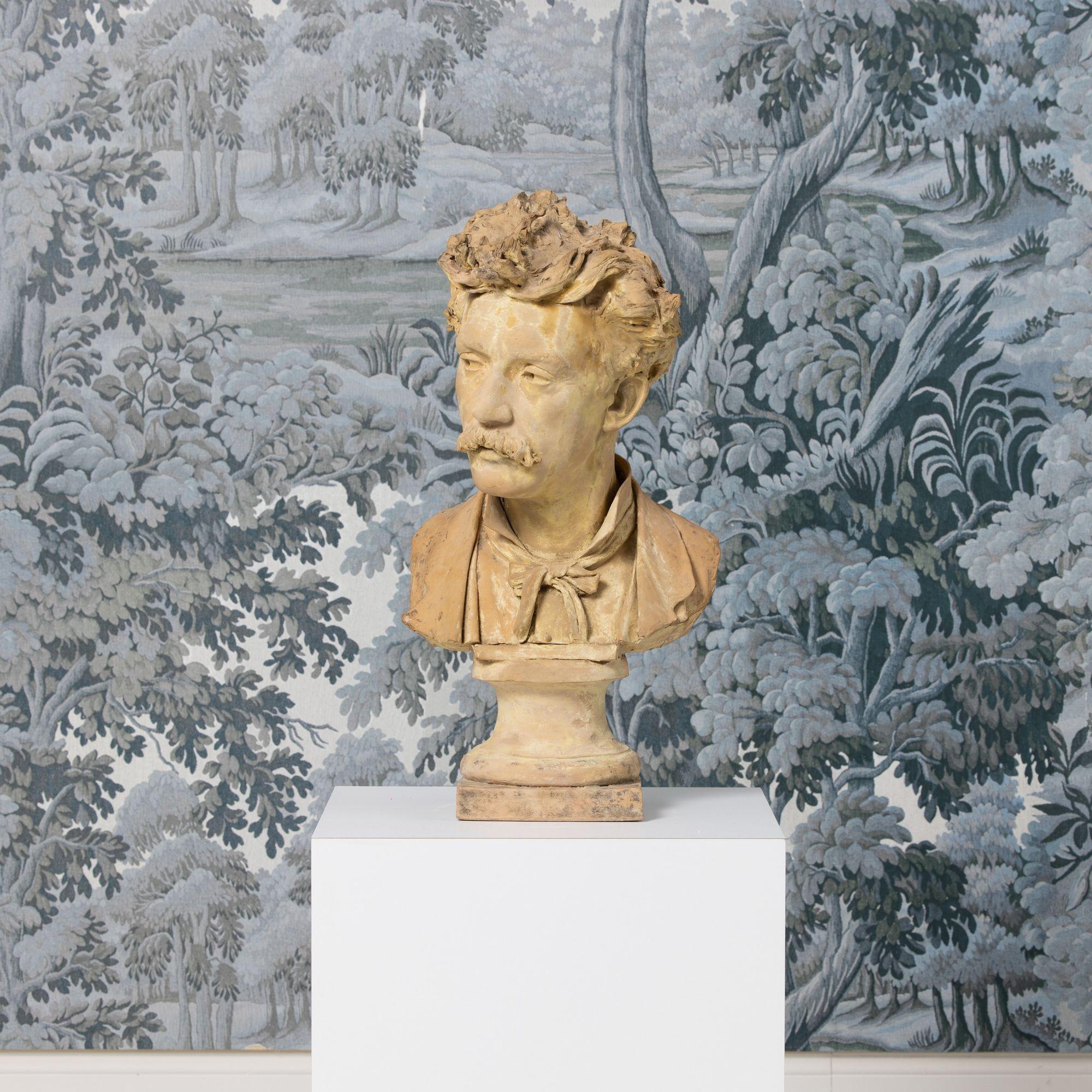 Questo busto francese del XVIII secolo di un artista in terracotta gialla mostra una notevole attenzione ai dettagli. Questa scultura ritrae l'artista con baffi, capelli spettinati e occhi sognanti che indossano un nastro come cravatta. Il busto è
