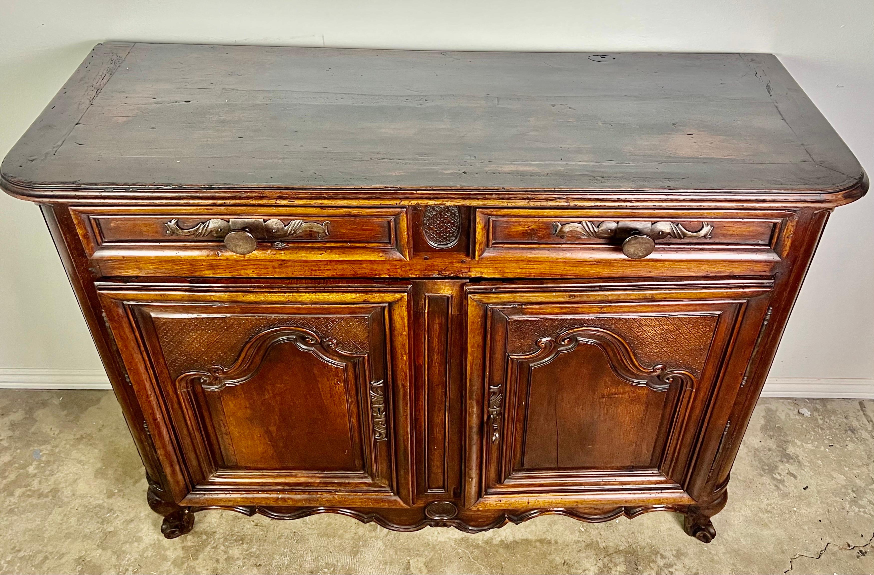 18th century French walnut Louis XV style buffet. The finish has developed a perfect patina that we long for. The buffet stands on four cabriole legs that end in rams head feet. There are two drawers and two doors with plenty of storage inside.