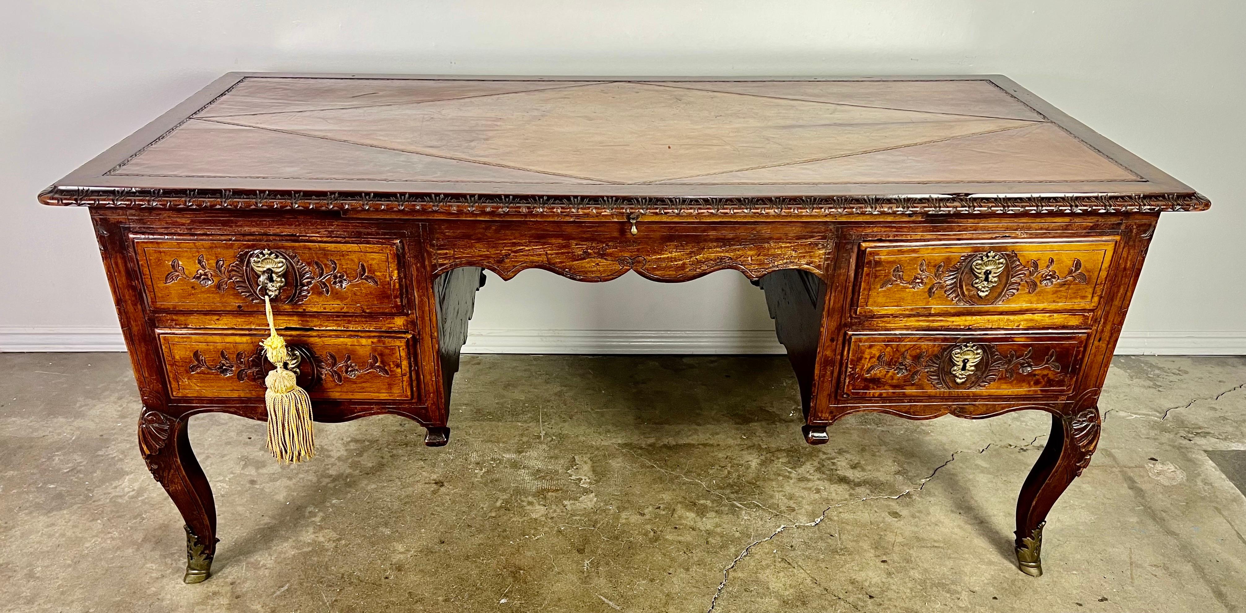 Late 18th century hand carved French provincial desk. The desk is carved in walnut and is extremely heavy and sturdy after all the year's of use. The finish has developed a beautiful patina that only comes from years of taking care of the wood by