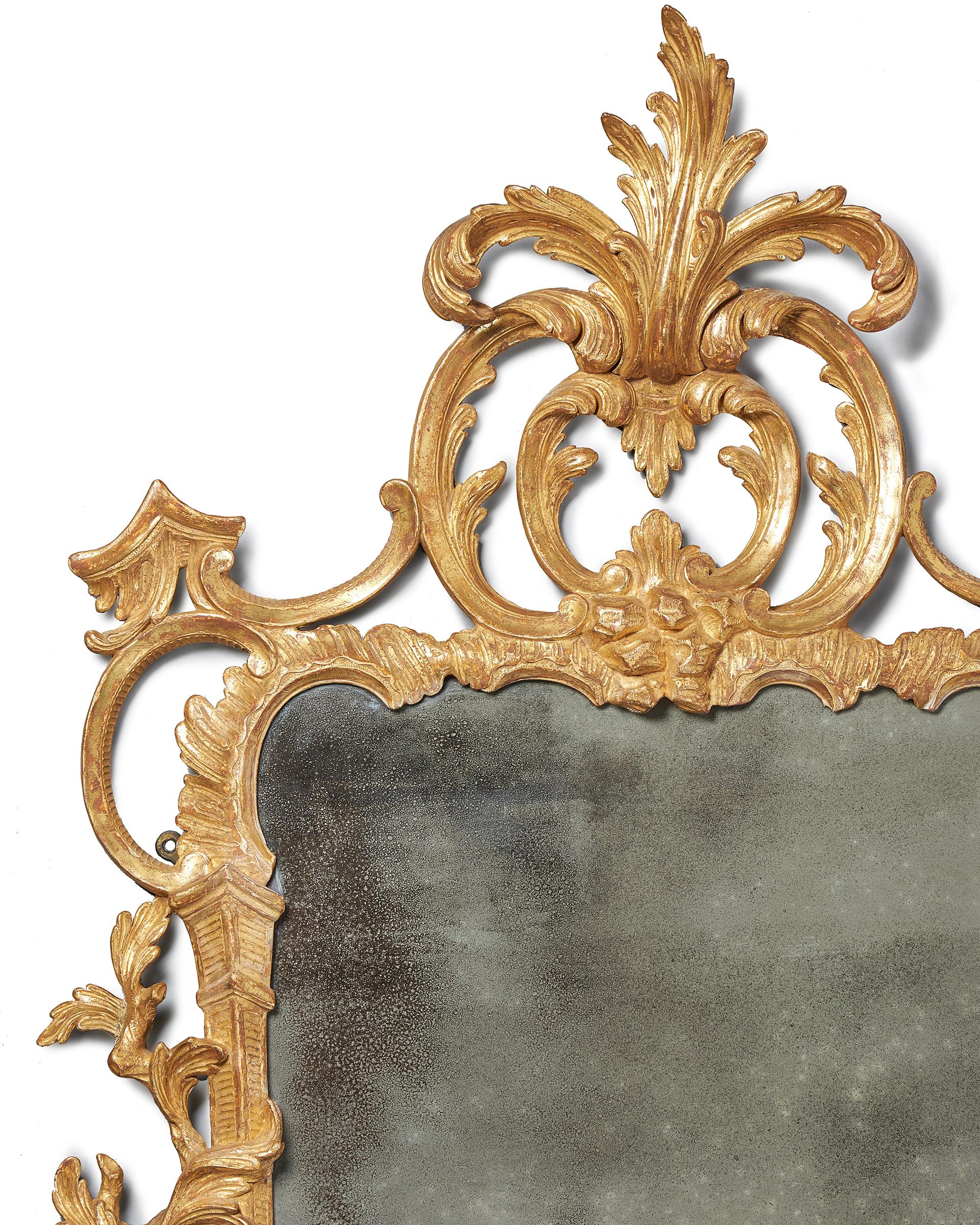 A rare and important George III 18th century Chippendale gilt mirror. 
The plate is within a carved foliate branch C-scroll, rocaille and acanthus carved surround, surmounted by an elaborate acanthus spray cresting.

Measures: H 131 cm x W 68