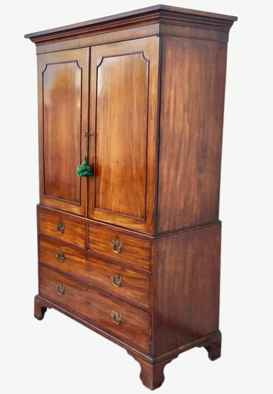 Very fine and impressive George III Period Linen Press, c. 1790s. A rectangular form made from highly figured Mahogany. Features a two over three drawer chest base with bracket feet and brass hardware. All drawers are lined with a silk fabric. Hutch