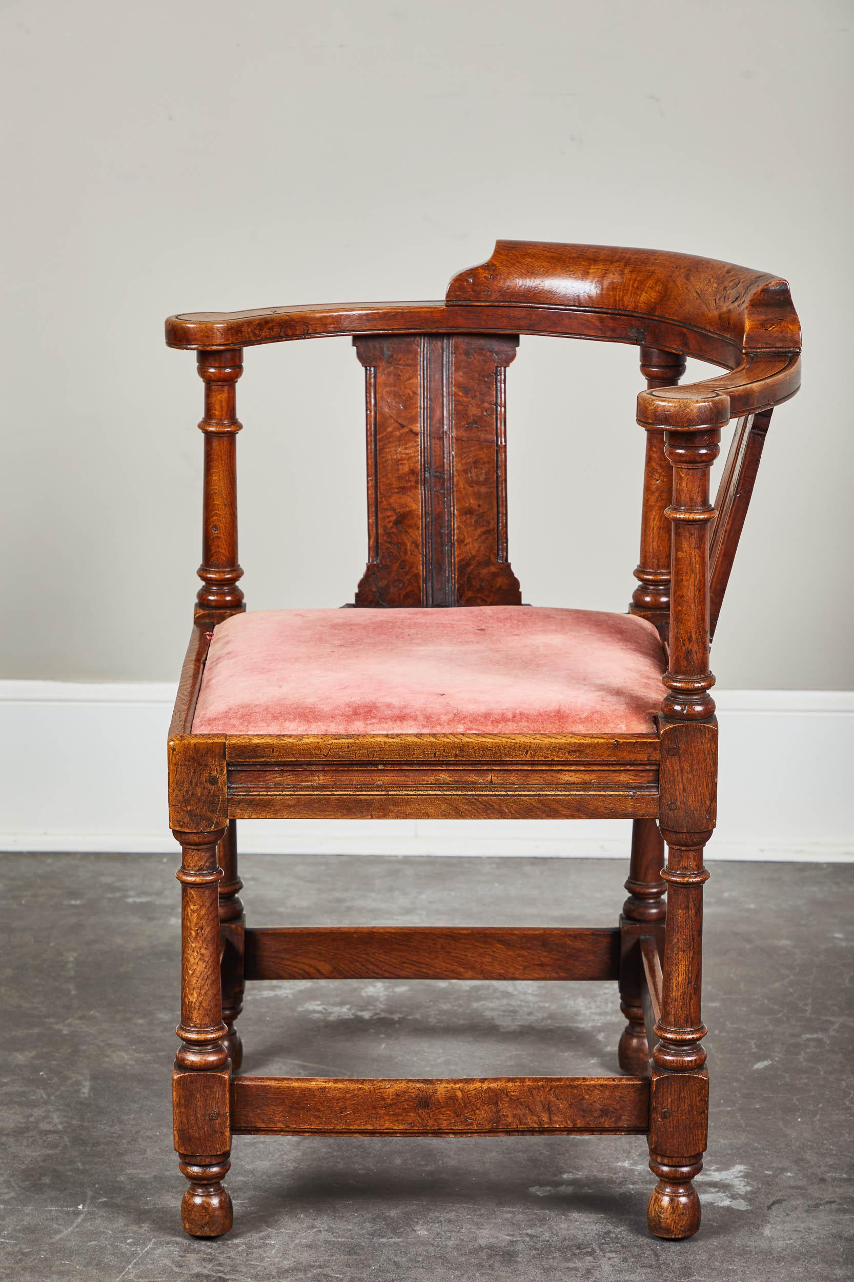 Late 18th century oak and burl yew wood library corner chair with rich burl and tone. English, turned legs and posts. Minor repair done on stretcher - done previously and very well. Simple carving on arm rests and splats. Muted red velvet seat