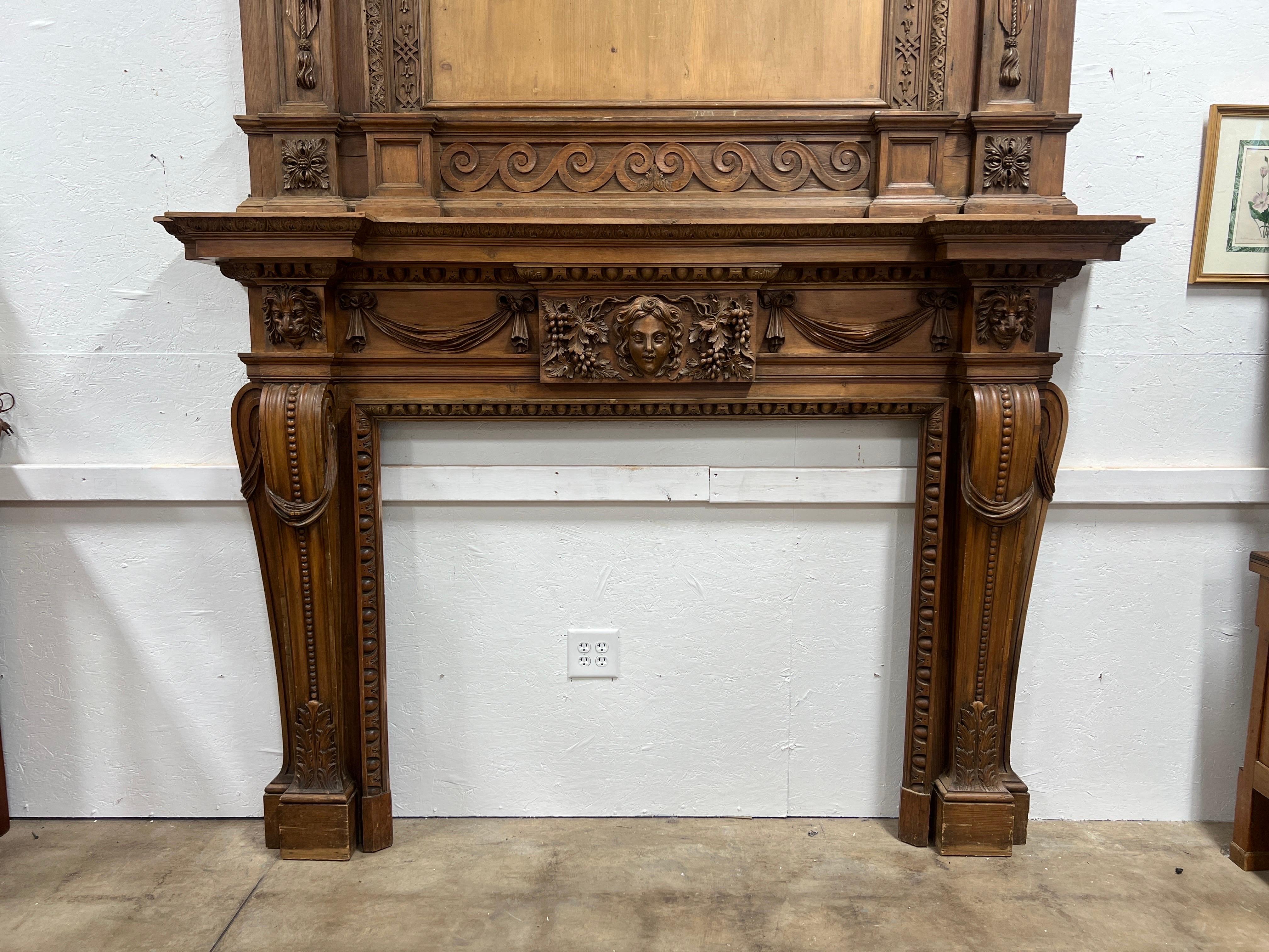 English, 18th century. 

A Palatial 18th Century Georgian Carved Pine Mantel with Overmantel, executed in the distinguished style reminiscent of the renowned architect and designer William Kent. 
The fireplace surround features an impressive array