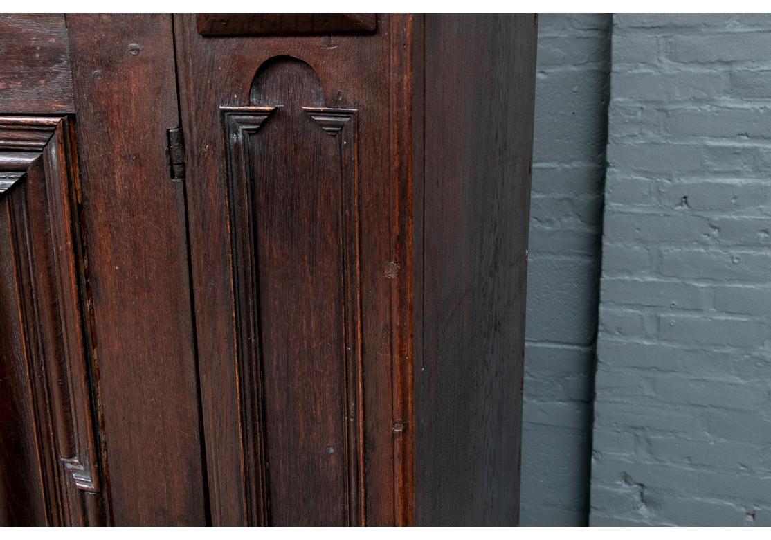 A large and authentic German Armoire in all original condition. A dark stained oak armoire made in three sections and inscribed for the owner and dated to 1731 on a band above the doors. The tiered cornice over a top with small carved doors, the
