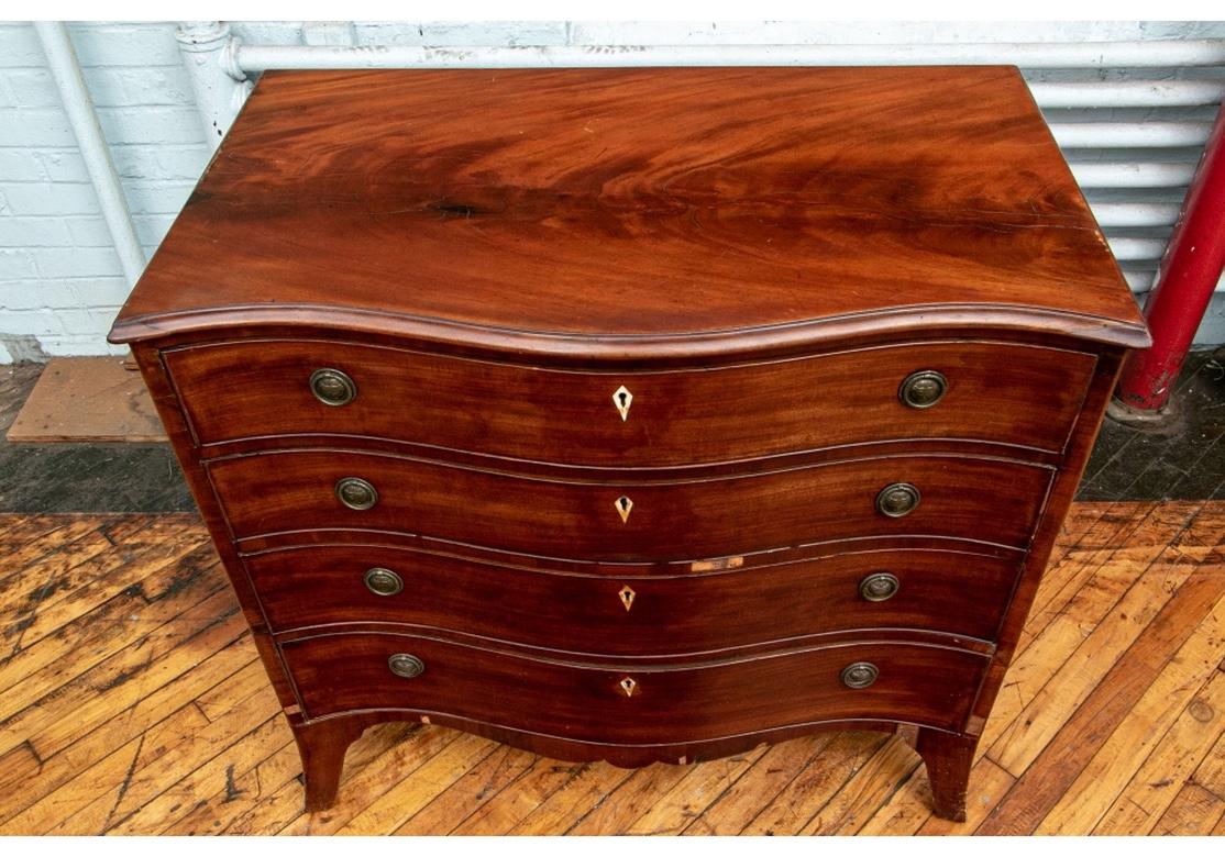 An early chest requiring restoration. With a serpentine case, the top drawer opens to a secretary/ toilette section with a green felt cover, compartments (some with lids), two glass lidded jars, and a center lift up mirror. Over three graduated long
