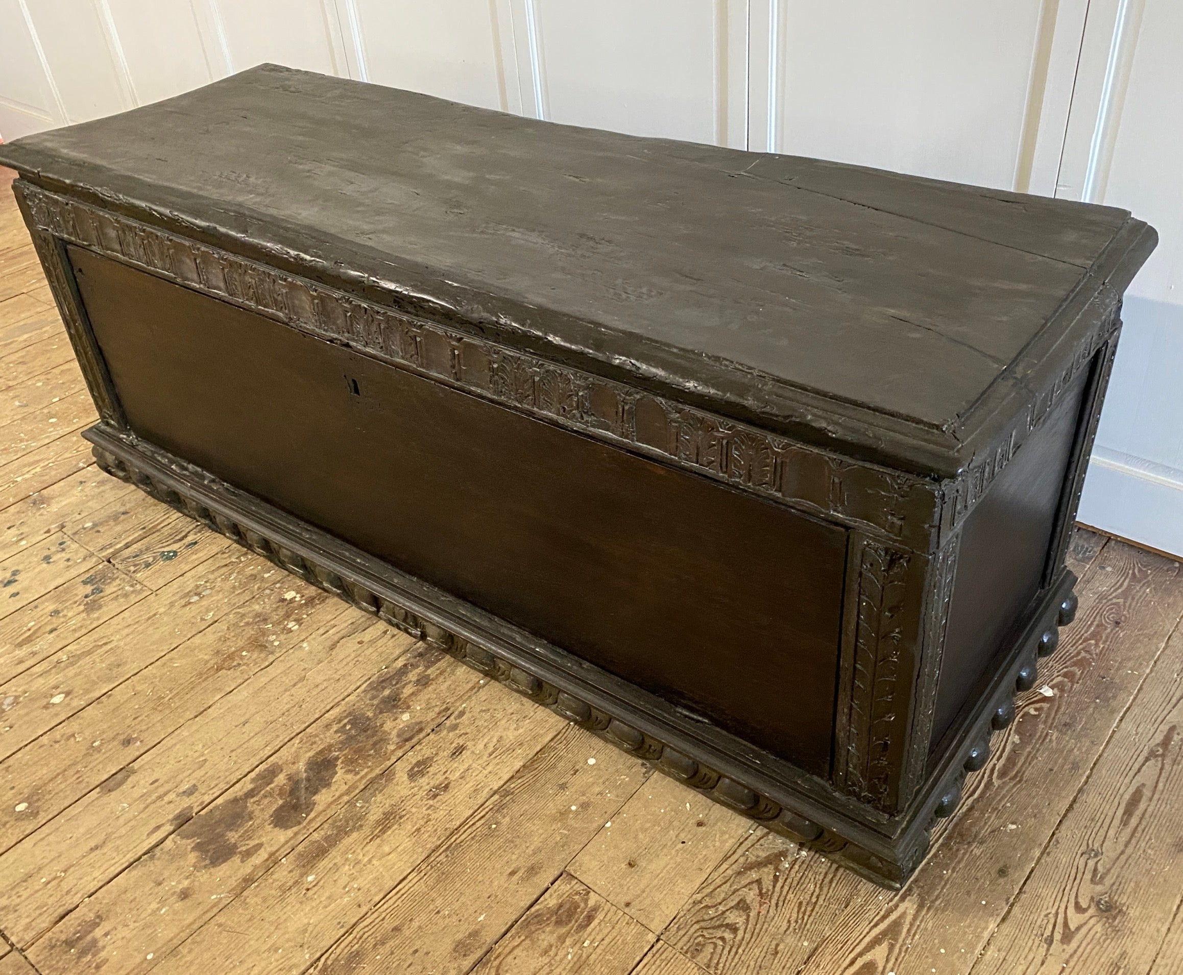A wonderfully rustic early Italian hand carved cassone with egg and dart moulded frame, time-softened wood and solid panels on the front and sides. Although this chest has suffered wood worm damage, losses to various areas and repairs made, it has