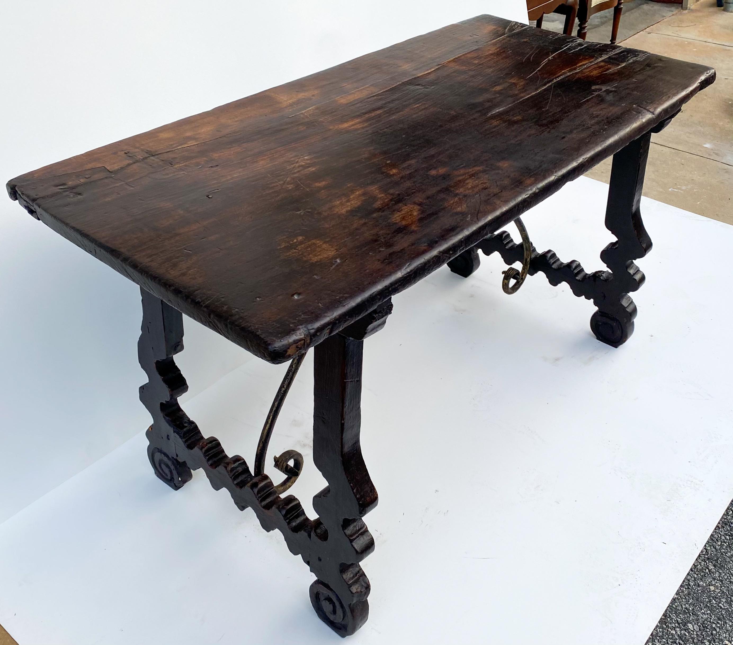 This is a 18th century Italian carved walnut table with iron stretcher. The walnut is single plank construction. The iron cross stretcher is hand forged. Great piece with age appropriate wear.