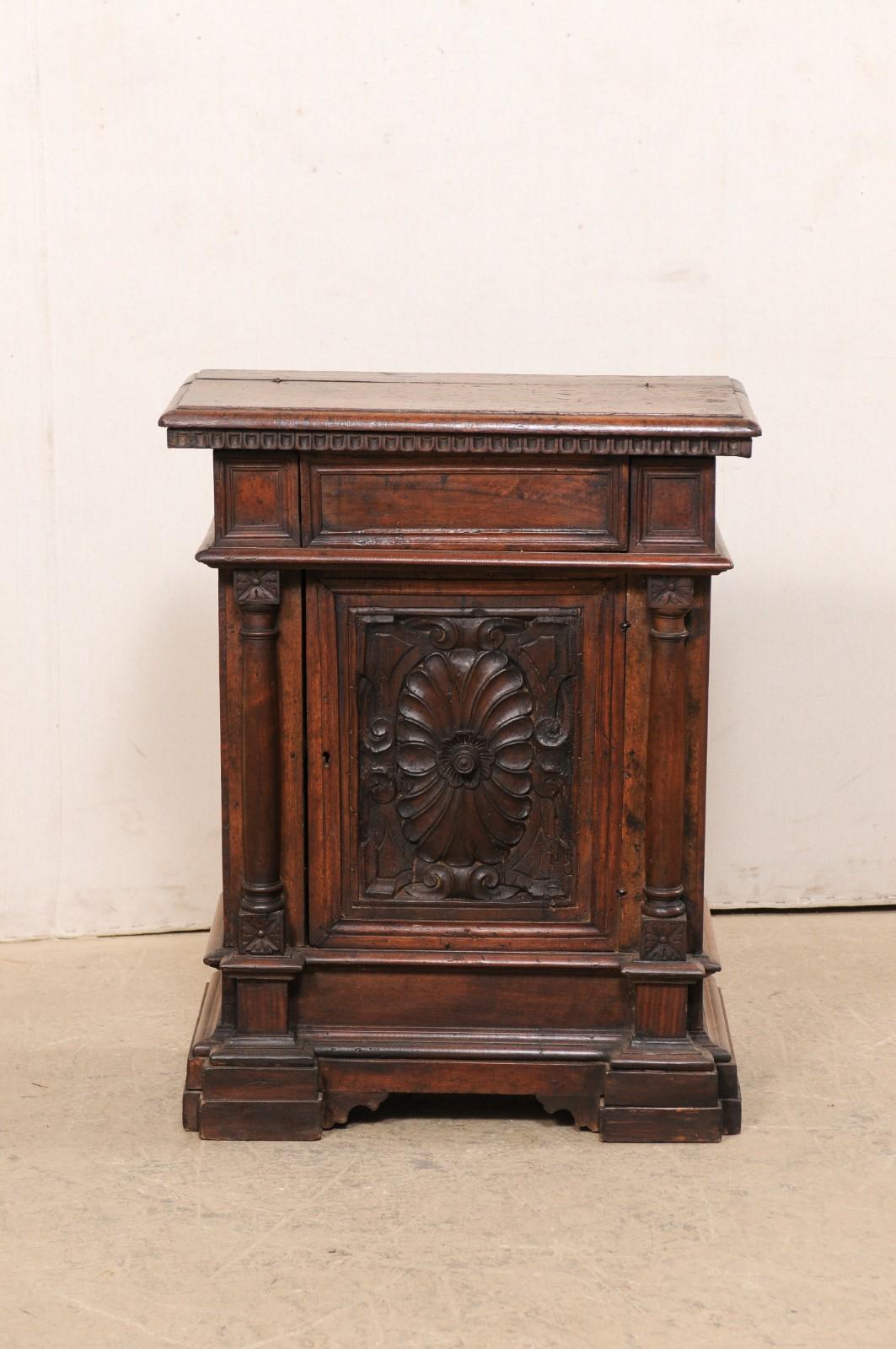 An Italian small-sized walnut wood cabinet, with butler's desk style top, from the 18th century. This antique chest from Italy has a rectangular-shaped top, with hand-carved egg-and-dart trim along it's underside, which rests atop a case which