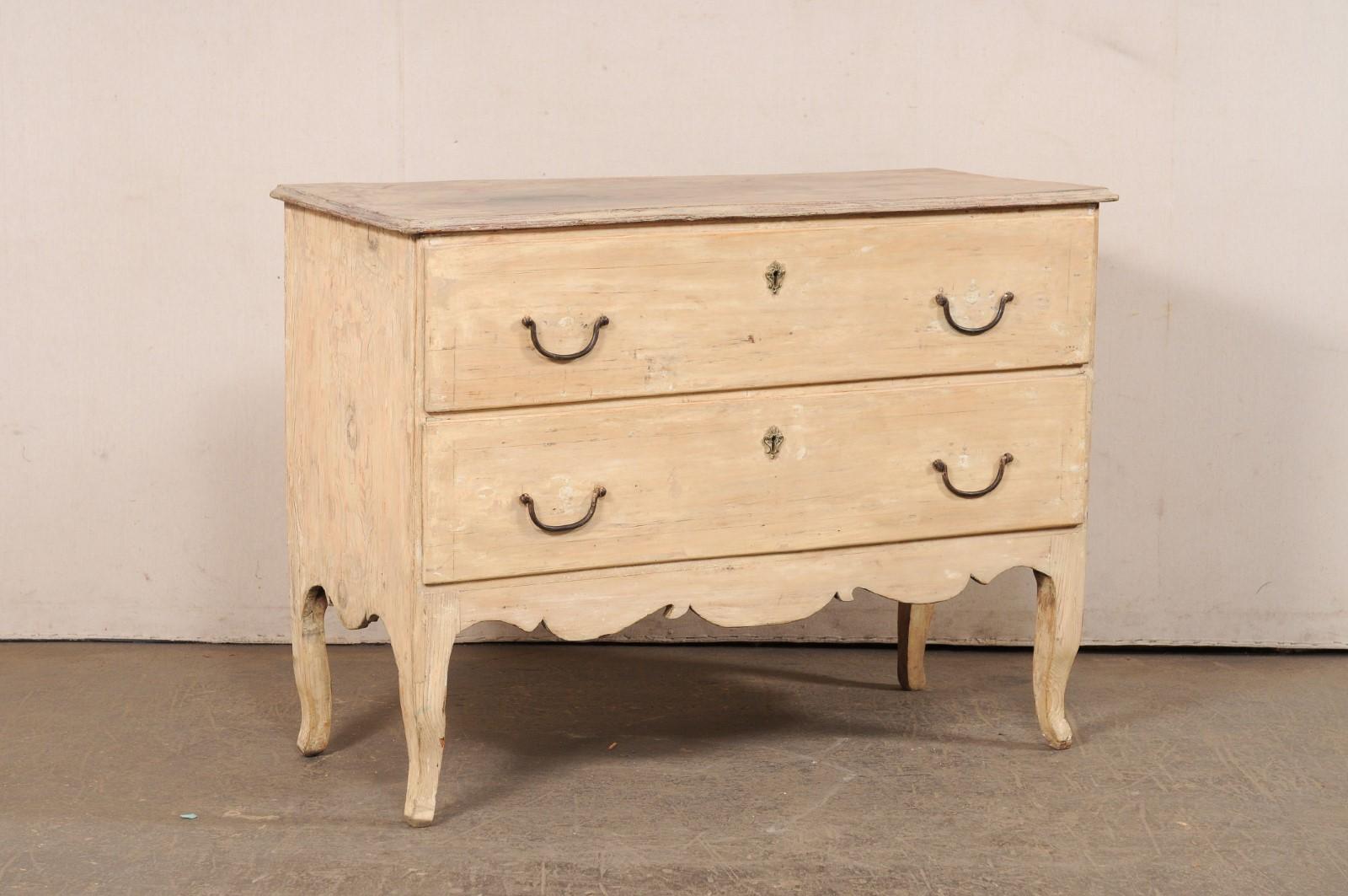 An Italian carved-wood raised chest of two drawers from the 18th century. This antique cassettiera (chest of drawers) from Italy features a rectangular-shaped top, over a case which houses two full-sized drawers, and a decorative scalloped skirt