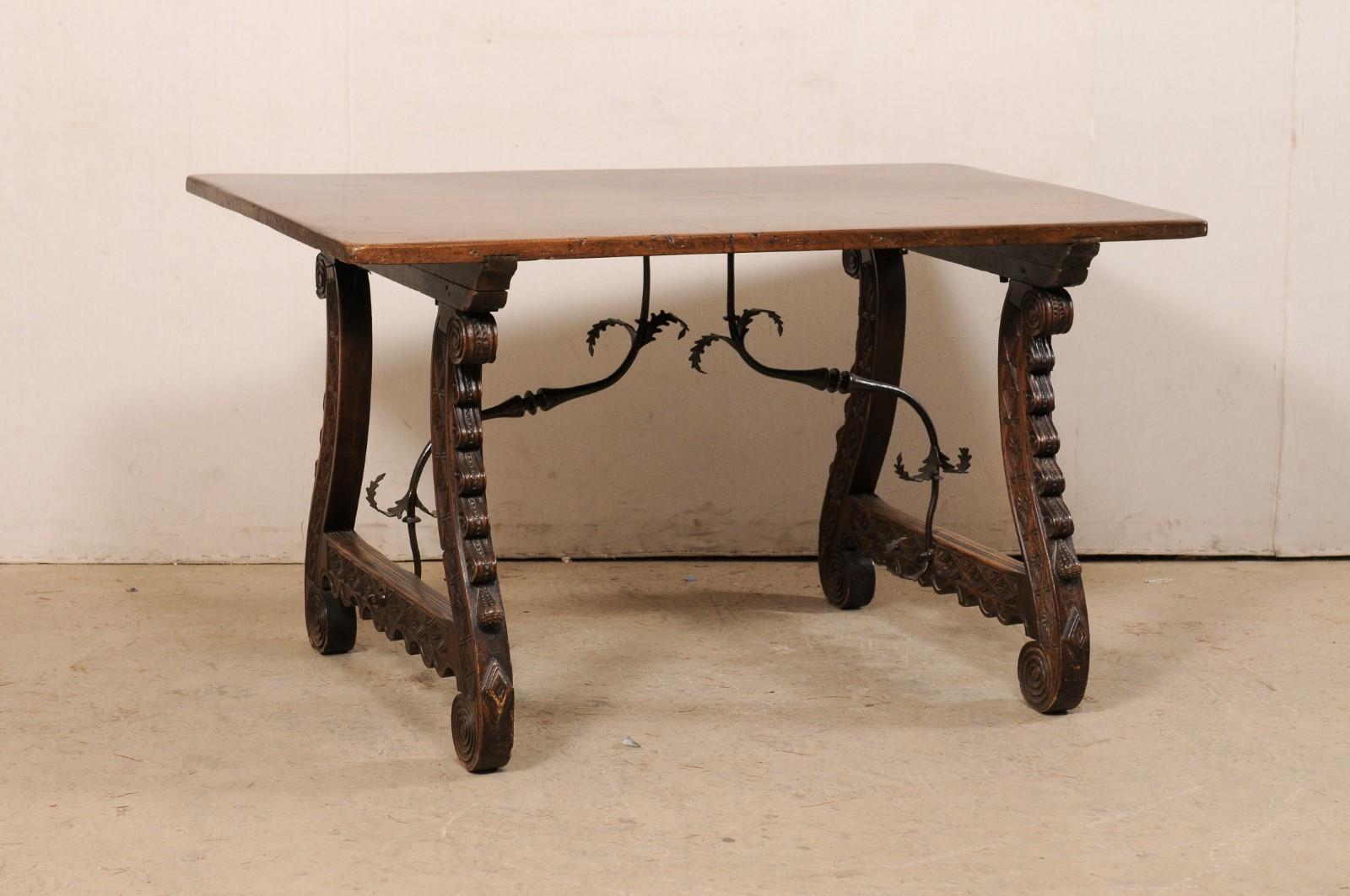 An Italian walnut wood nicely-carved trestle-leg table with decorative forged-iron stretcher, from the 18th century. This antique table from Italy features a rectangular-shaped top, which is raised upon a pair of lyre-shaped, trestle-styled legs,