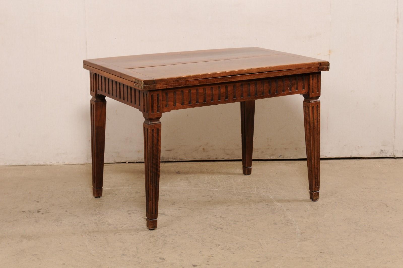 Une table italienne en bois sculpté avec plateau transitionnel/pliant du début du 20e siècle. Cette table ancienne d'Italie est dotée d'un plateau pliable en deux qui peut être déplié et tourné pour créer un plateau plus large. Des sculptures en
