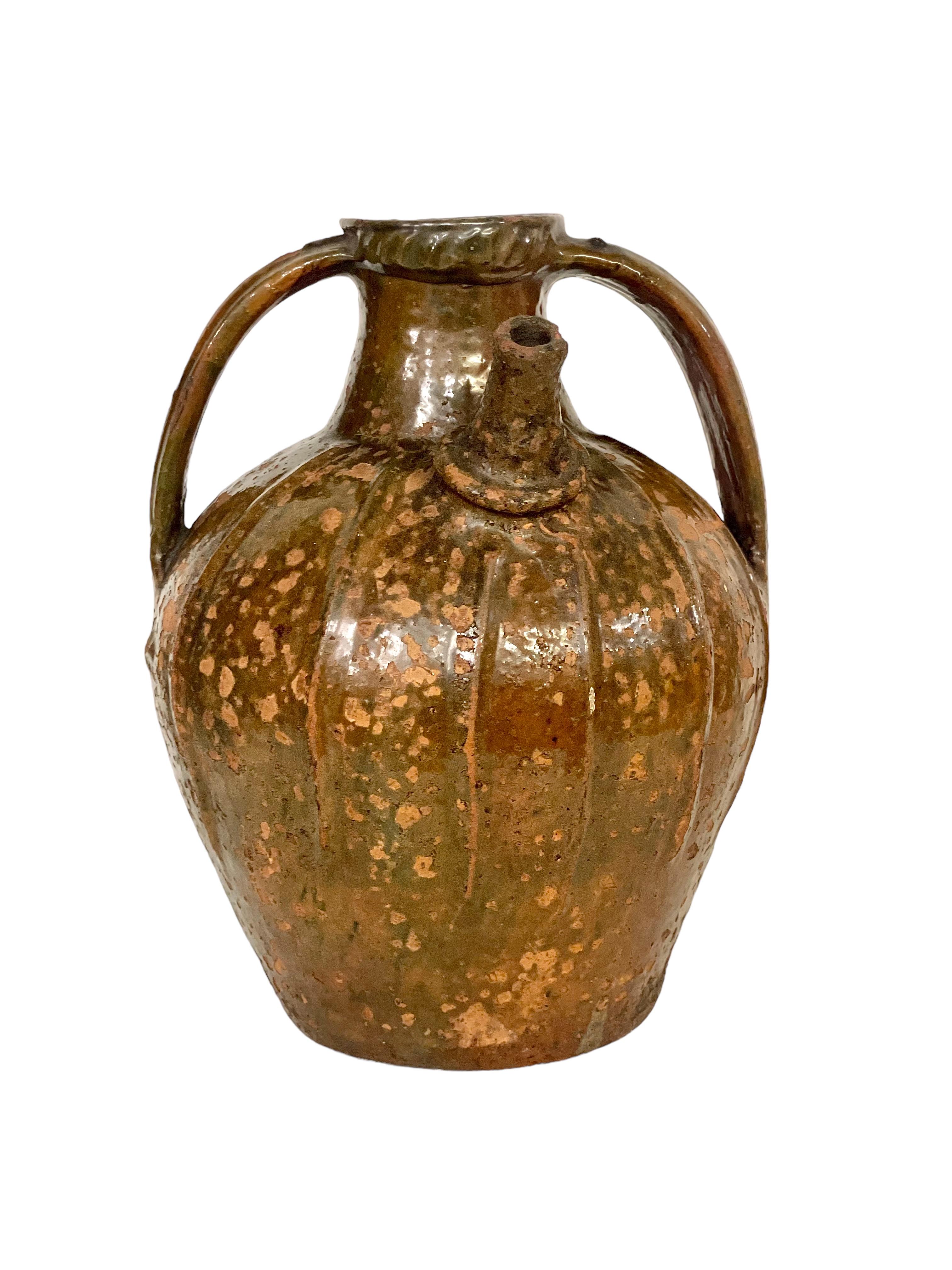 A large and very handsome glazed terracotta walnut oil jug, dating from the 18th century and originating from the south of France. Featuring two side handles and a single pouring spout, this beautiful vessel is covered with a gorgeous