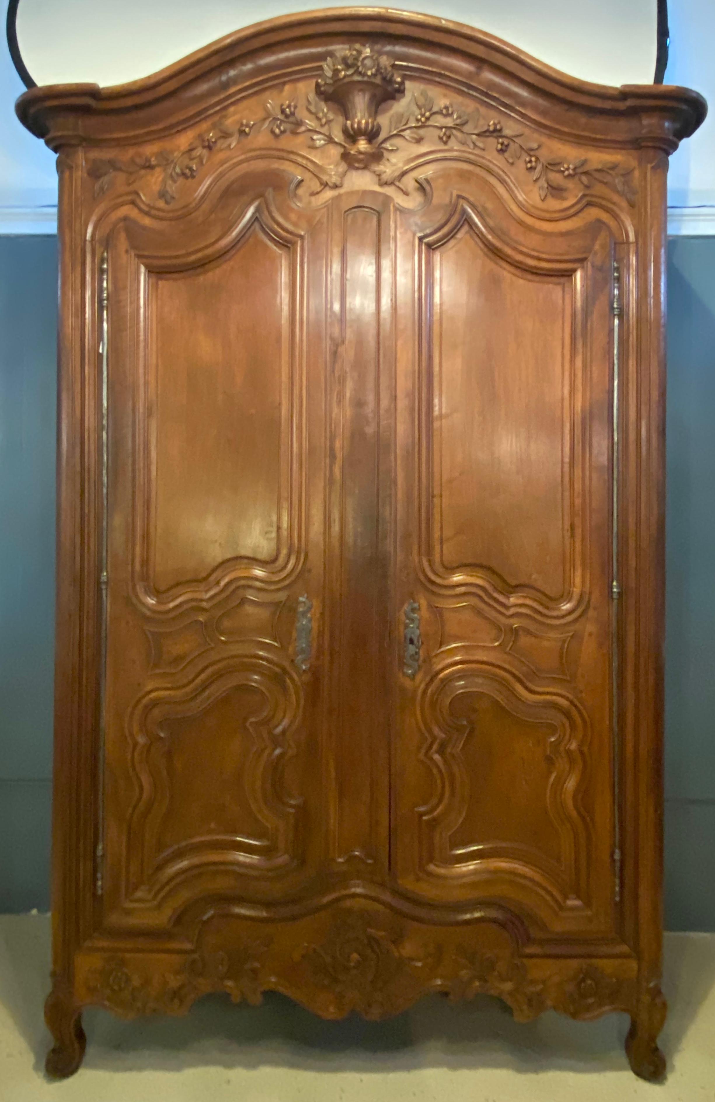 18th century Louis XV armoire wonderfully carved with all original hardware having a single key. This exquisite period armoire is simply stunning with the finest of carvings having double doors that open to a fitted shelved interior. Disassembles