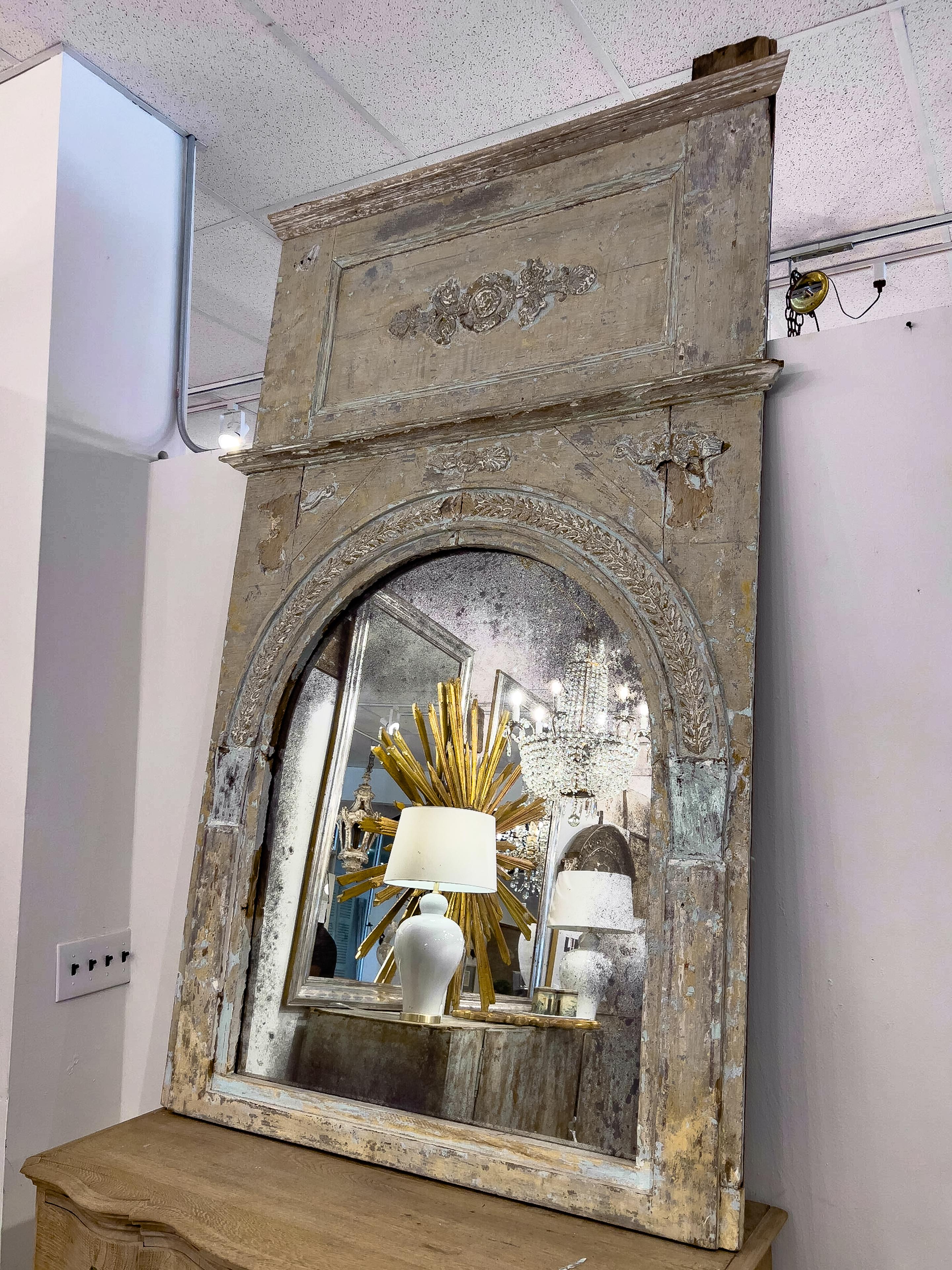 18th C. French Trumeau mirror with Neoclassical applique decoration and the original mirror that has dark inclusions and foggy appearance.