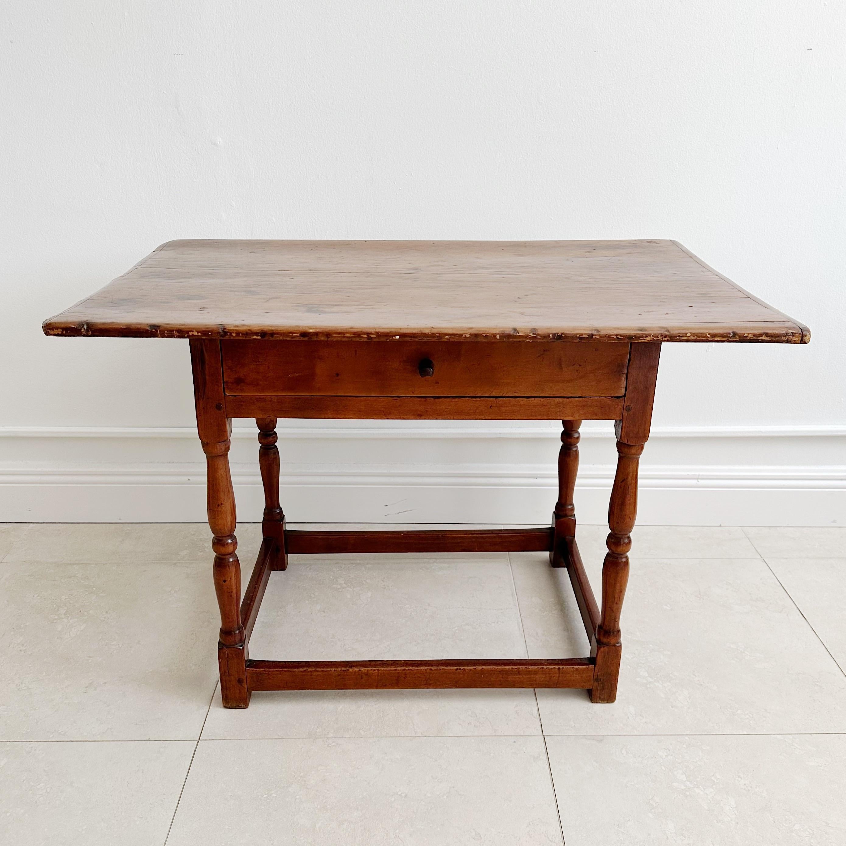 Exquisite 18th Century New England Tavern Table, the top being  crafted from one piece of  original walnut. This remarkable piece features an overhanging top with authentic breadboard ends, original maple base with handcrafted single dovetailed