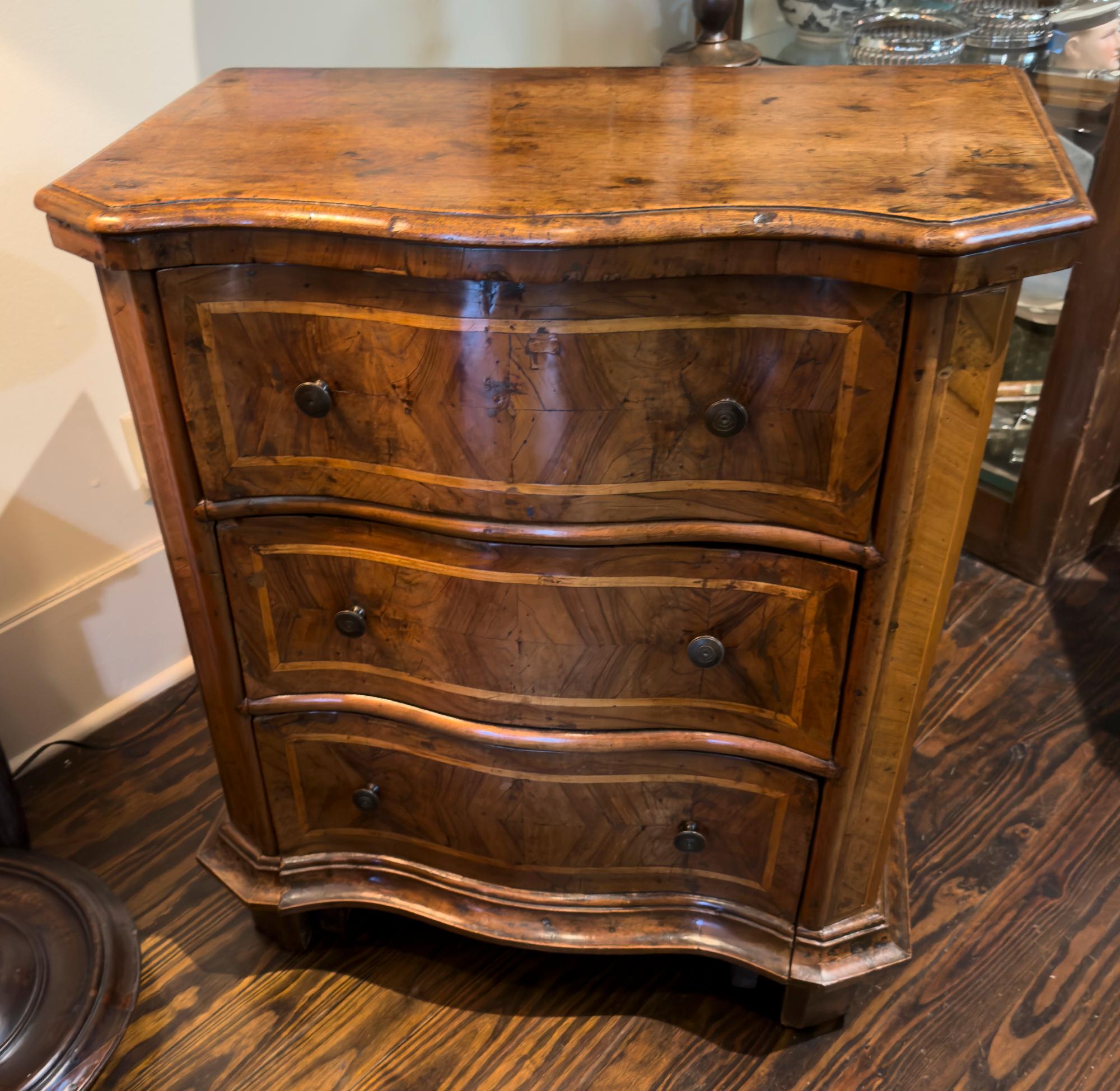 18th C North Italian Walnut, Serpentine Comodino. Very original condition. Cross banded with a very warm color and expressive figured veneers.
Great small scale and overall curvy design. the sides decorated with vertical, rectangular banded panels.