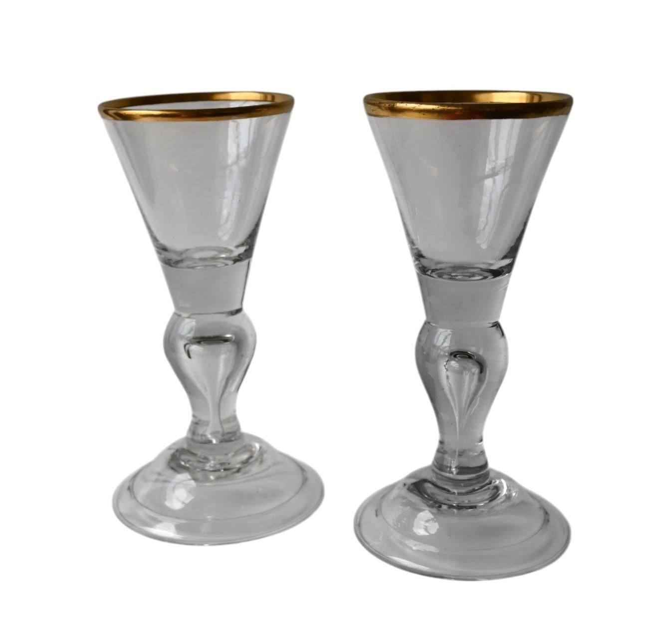  A pair very good hand blown wine drinking glasses, dating to the George II period of the mid-18th century, circa 1750.
These wine glasses are hand blown from English lead glass. It is heavy and has a soft grey color. The glass has the usual
