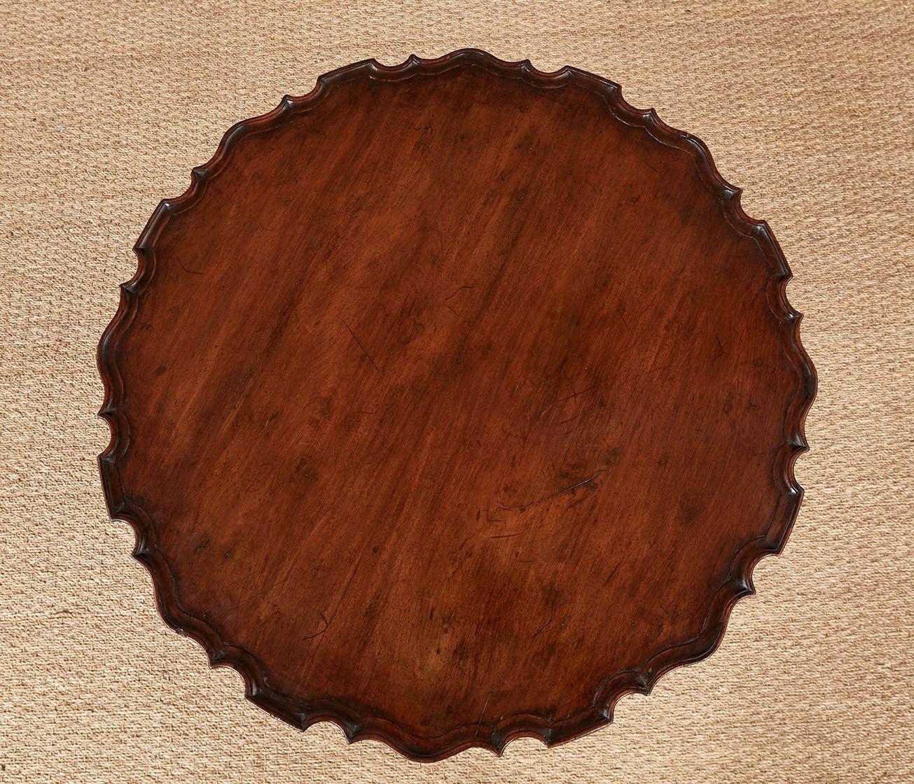 Tavolino da tè in mogano irlandese del XVIII secolo con piano intagliato a piecrust e meccanismo di inclinazione del piano su albero scanalato a spirale, in piedi su gambe triformi a ginocchio intagliato con piedi a ciabatta intagliati.
Alta 43