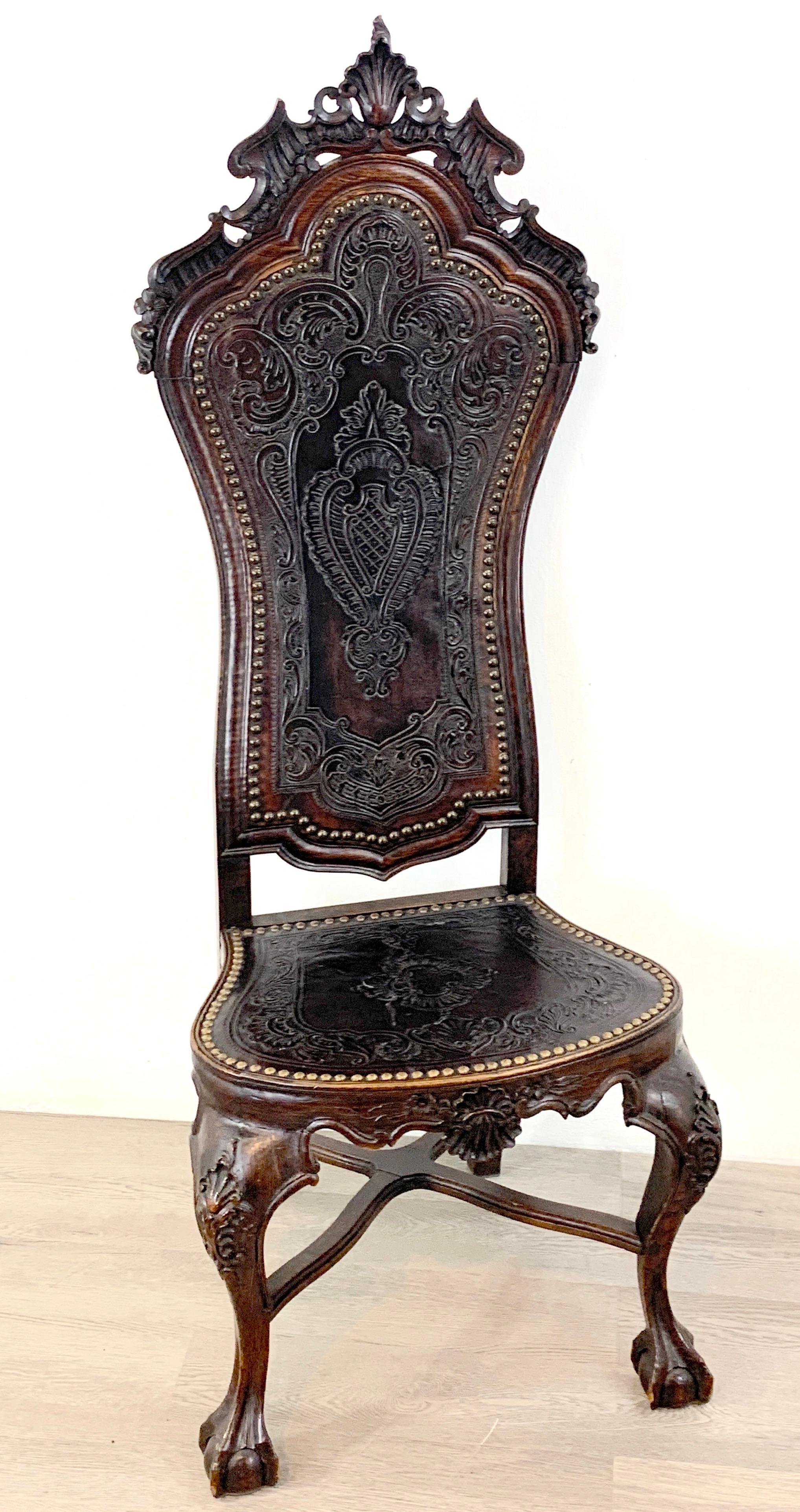18th C Portuguese carved Mahogany and embossed leather highback chair
With shell cartouche back, exquisite embossed leather backrest and seat, with brass nail heads. 
Supported on cabriole legs with ball and claw feet. 
Measures: 58