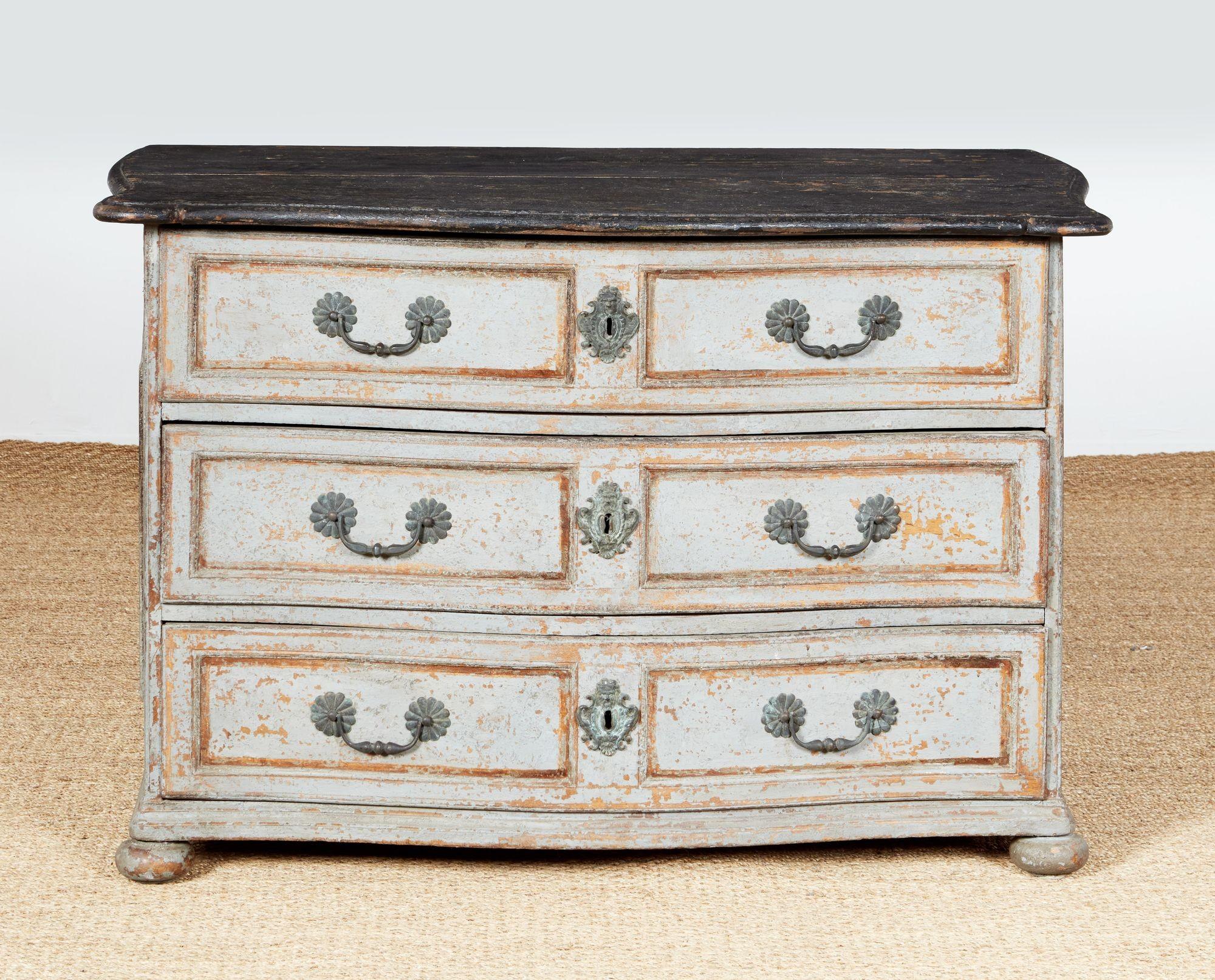 18th century baroque commode from Provence retaining wonderful dove grey painted surface. The shaped top with molded edge over three large paneled and shaped drawers retaining gold reveals, and the sides with raised and arched panels also with gold