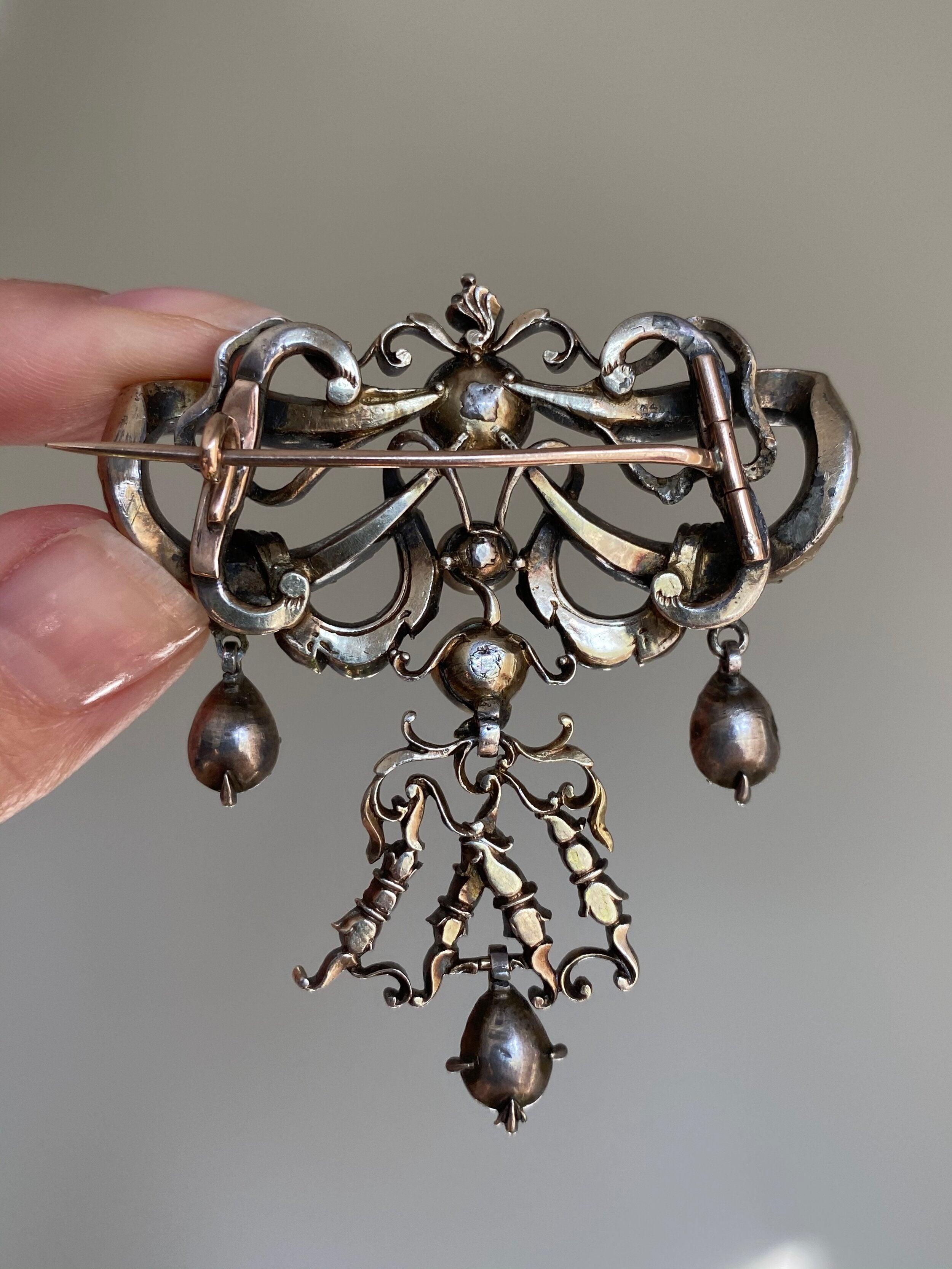 Dieses seltene und exquisite Juwel aus dem 18. Jahrhundert ist in Form eines fließenden Bandes gestaltet, das mit 24 edlen himbeerroten Rubinen im Tafelschliff besetzt ist, drapiert mit 16 schimmernden Diamanten im Peruzzi- und Rosenschliff und